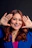 Woman with red hair framing her face with hands.