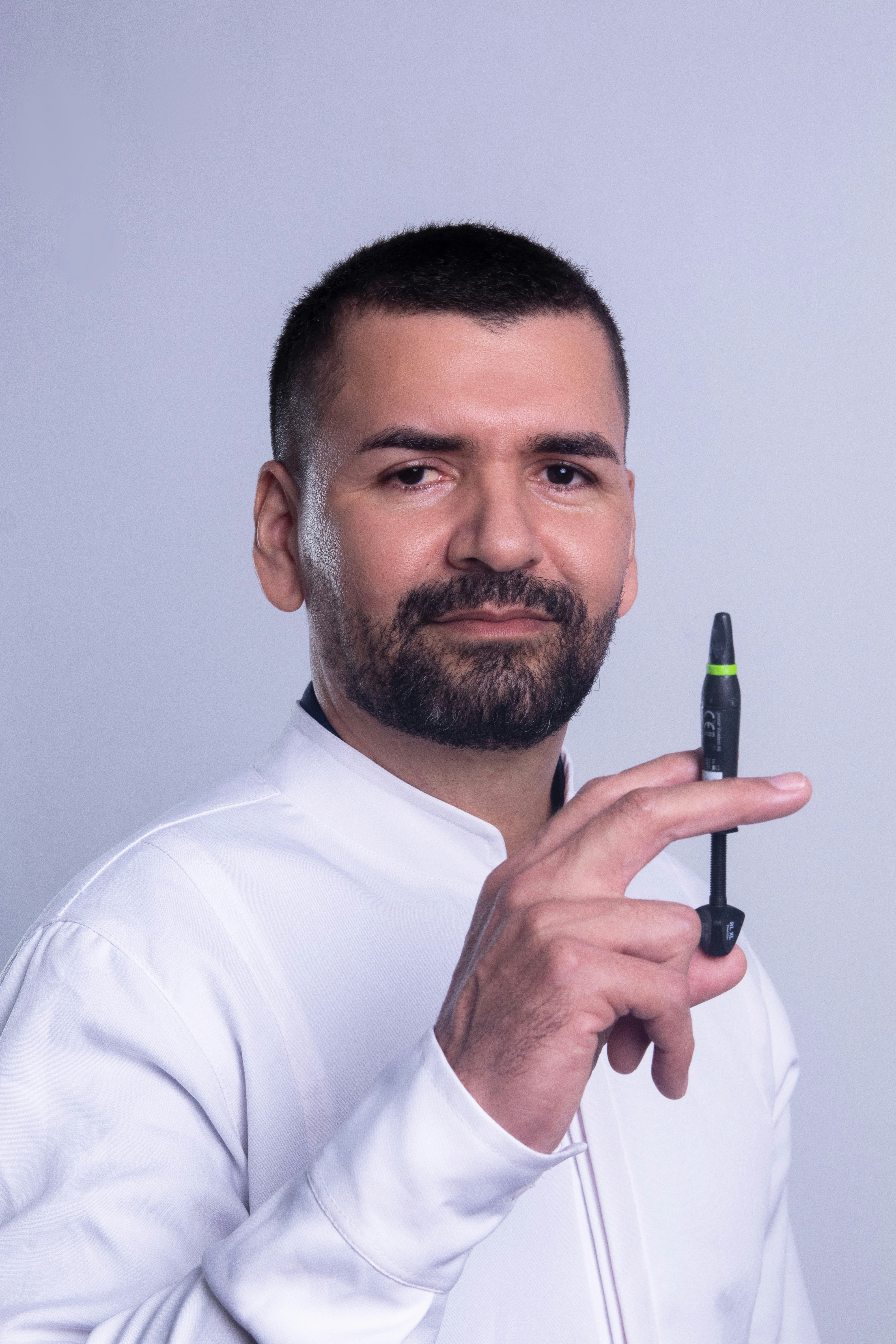 Hombre con bata blanca sosteniendo un dispositivo médico.