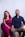 A smiling couple sits together on a modern chair.