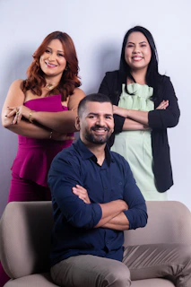 Three people posing confidently on a couch