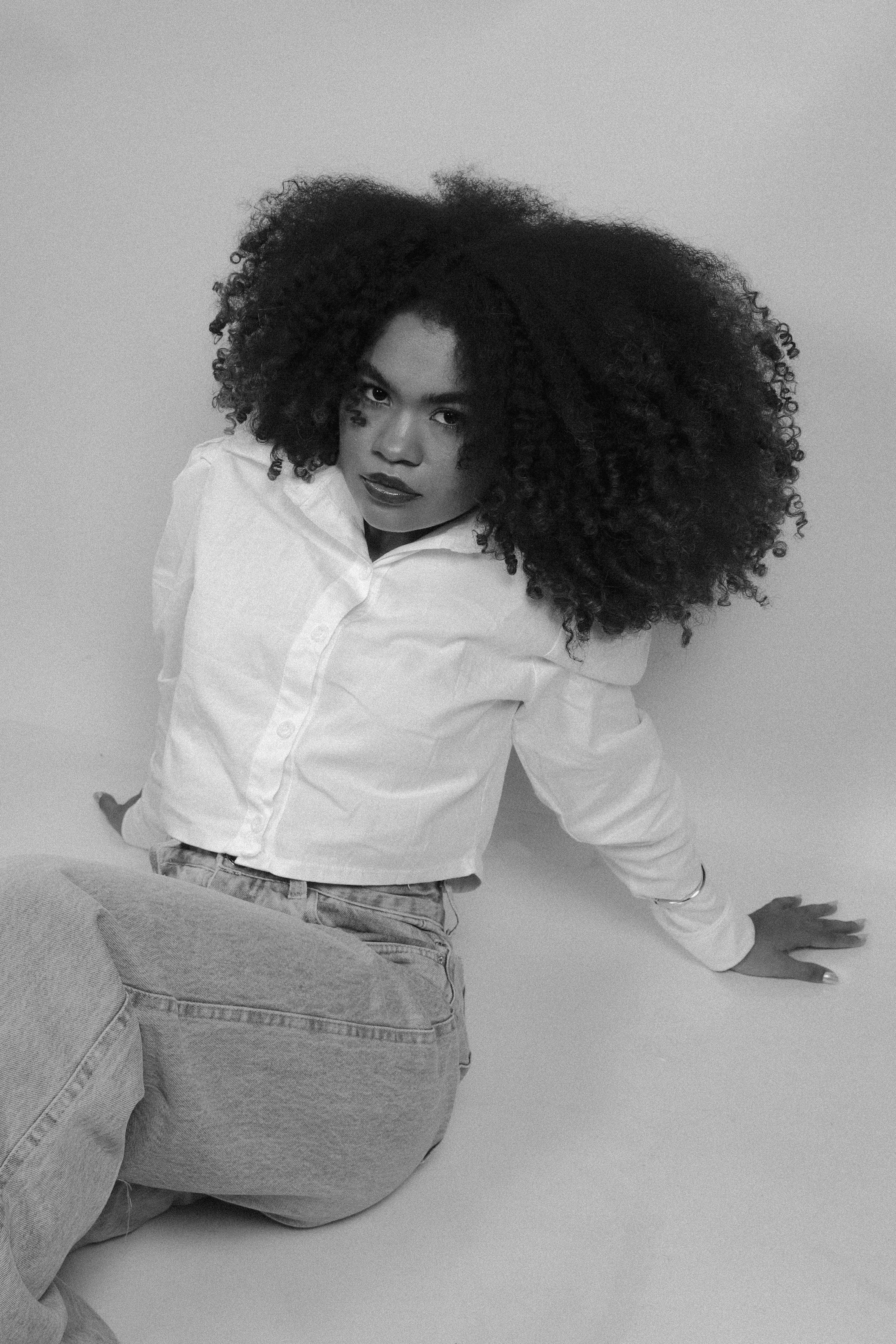 Woman with large afro wearing white shirt and jeans