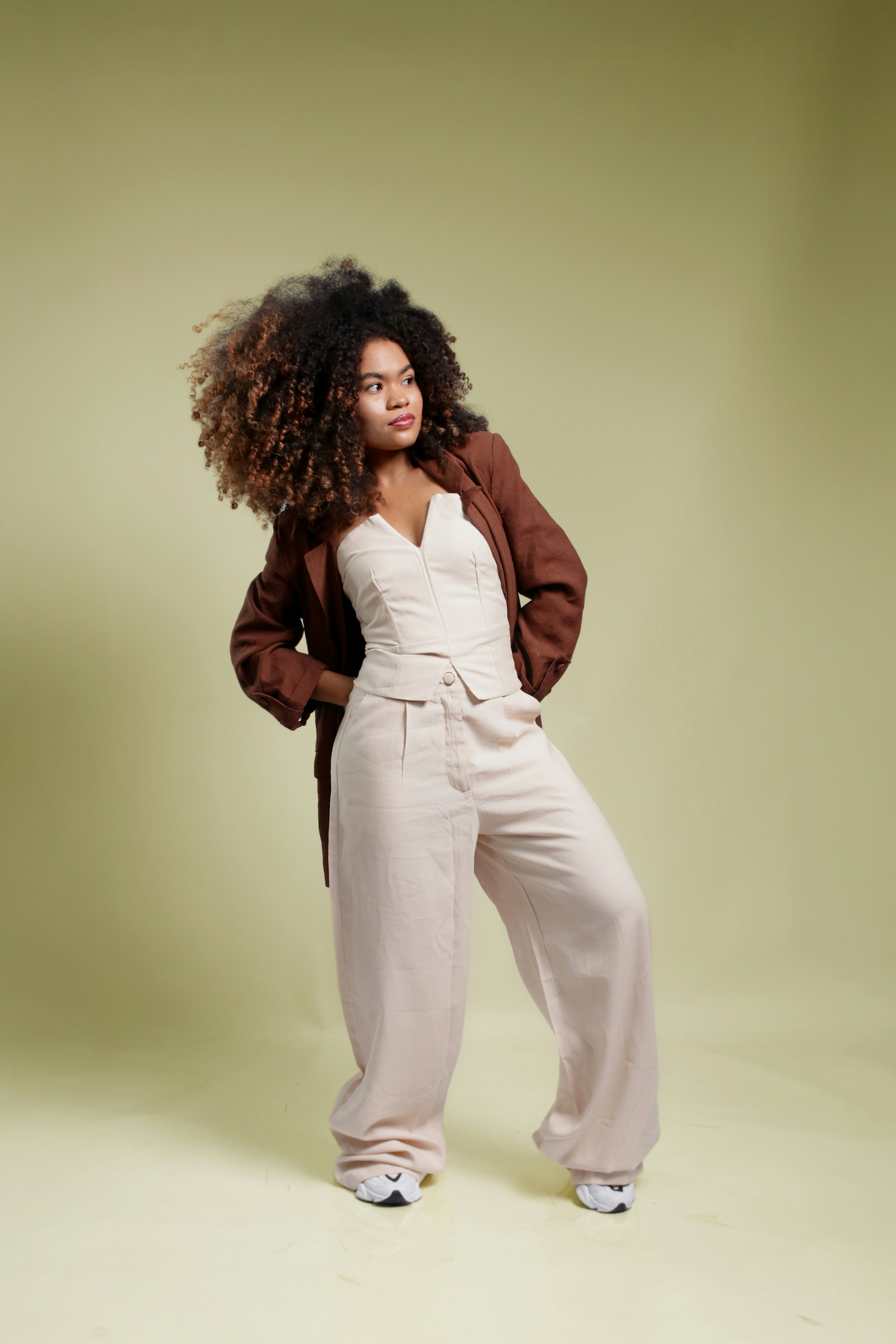 Woman with curly hair wearing a corset and pants