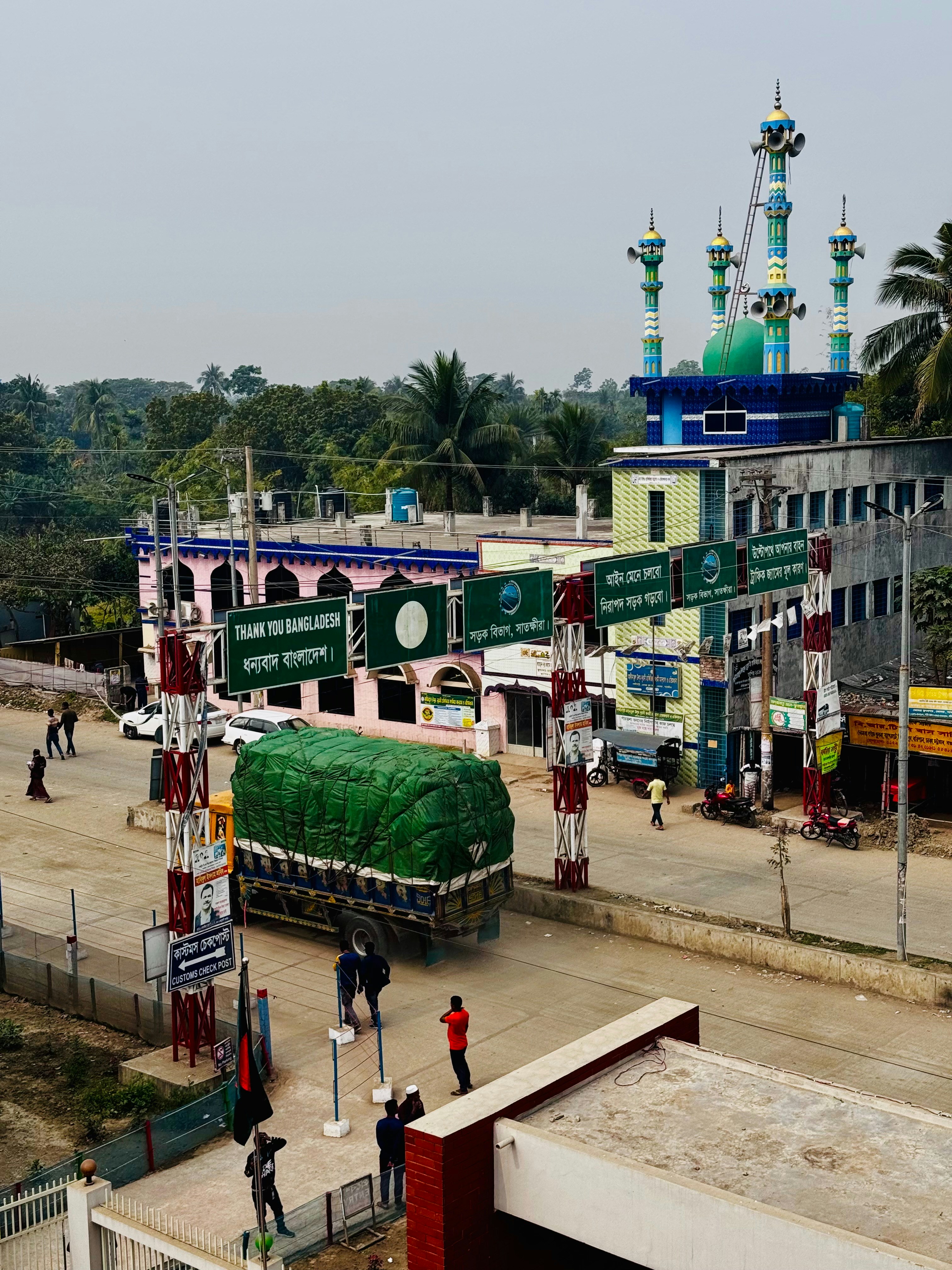 Truk melewati penyeberangan perbatasan dengan masjid.
