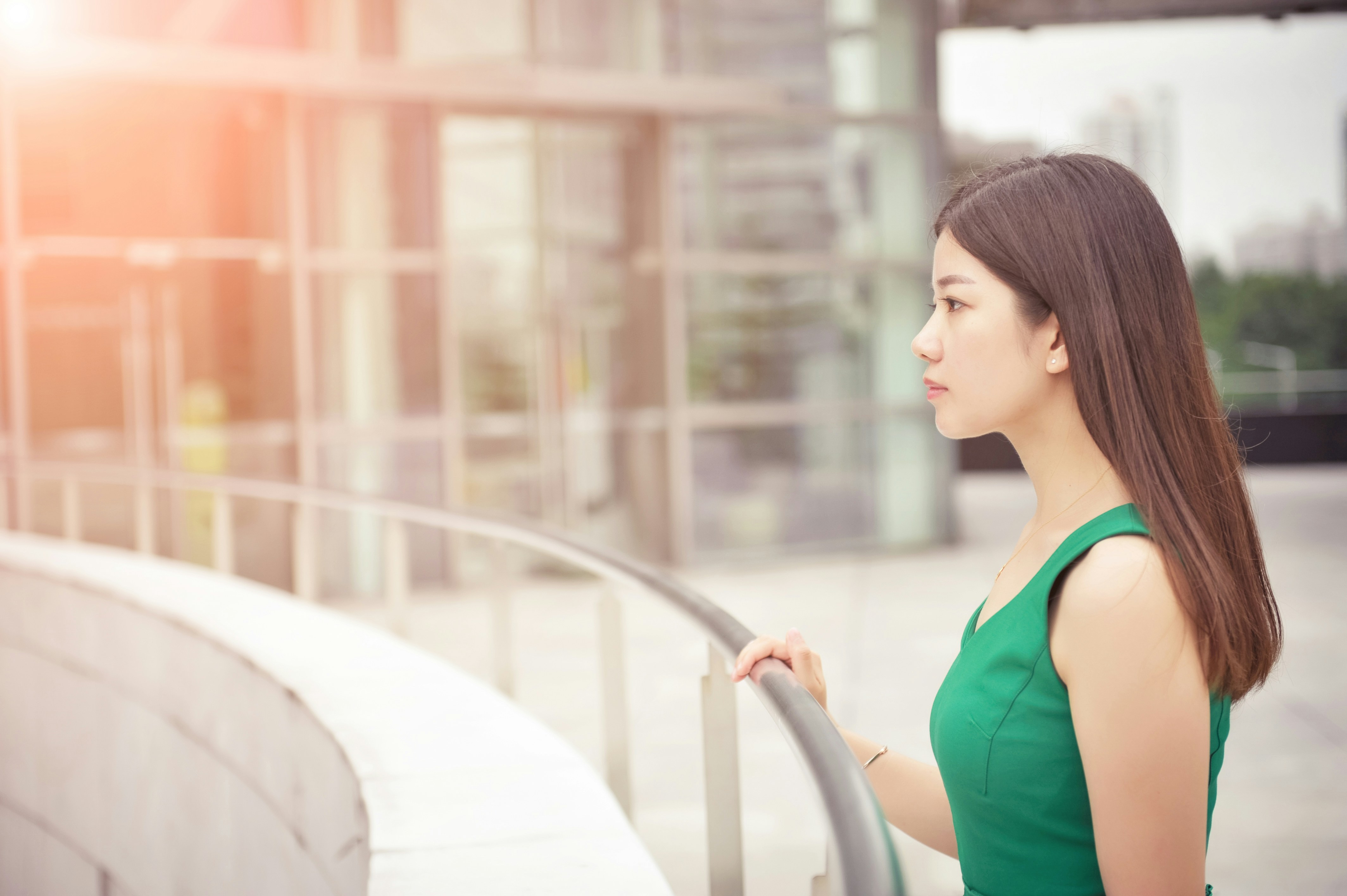Young woman in green dress looking out