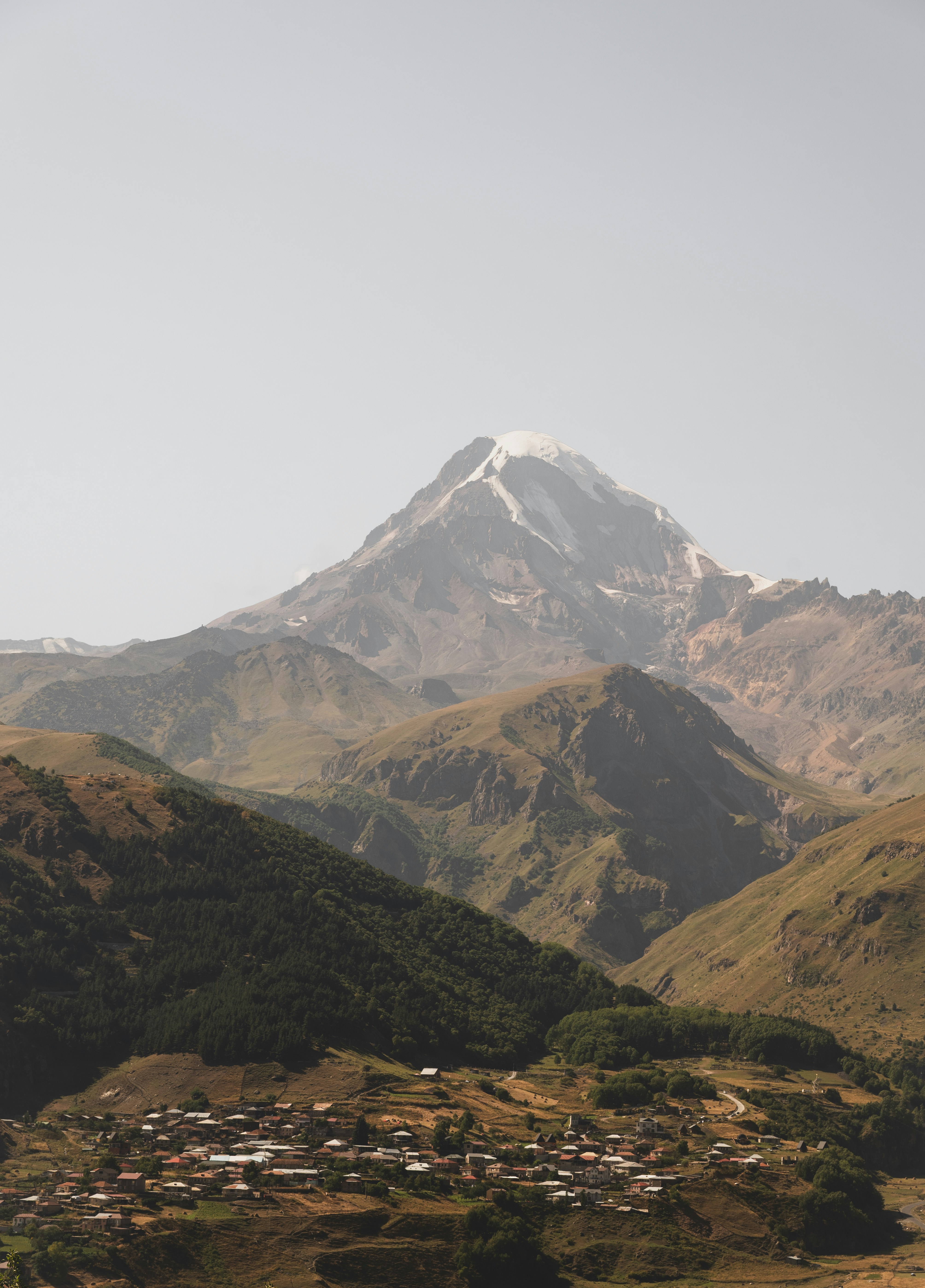 Snow-capped mountain peak above a village.