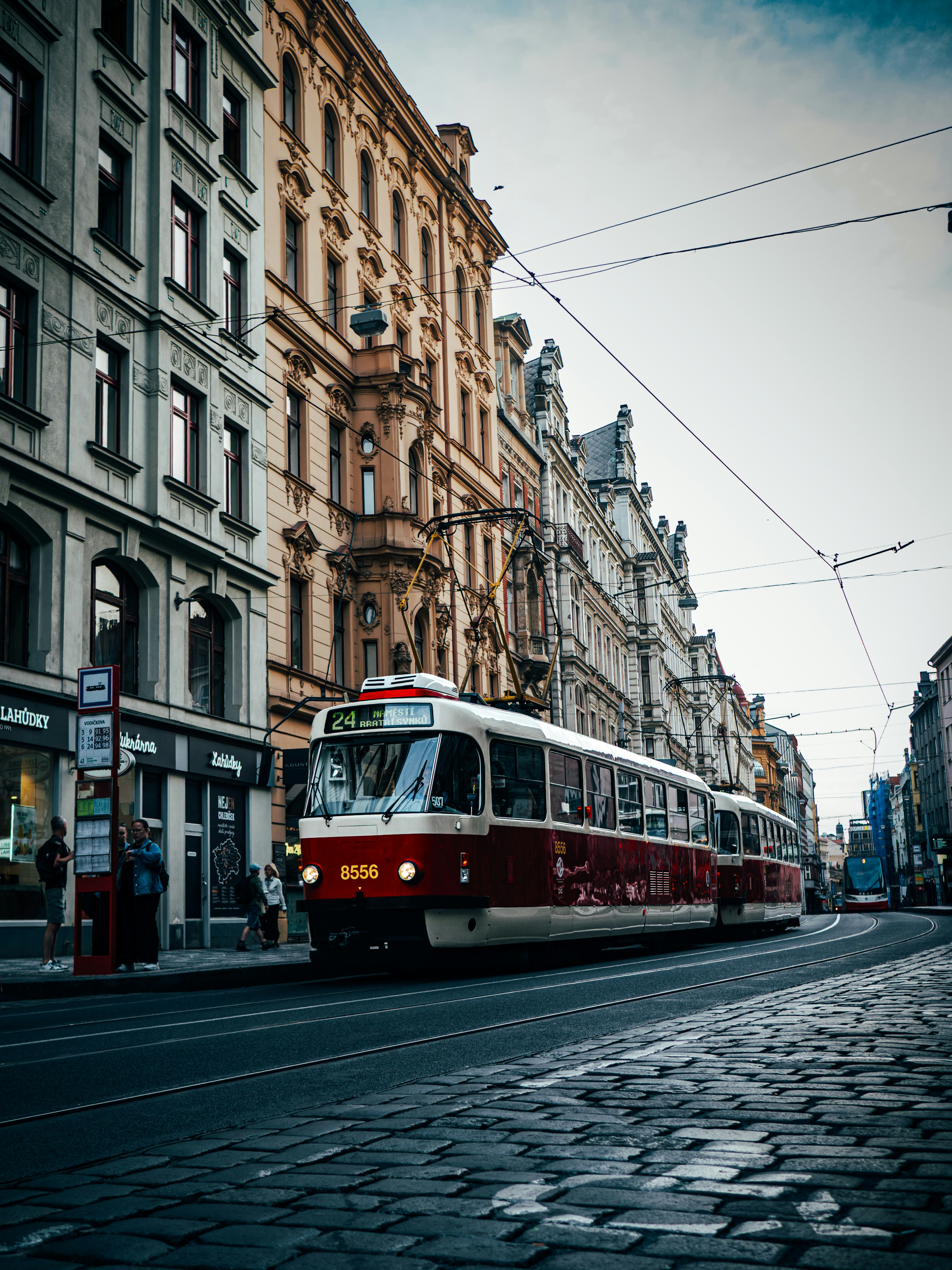 Rot-weiße Straßenbahn auf der Kopfsteinpflasterstraße in der Stadt.