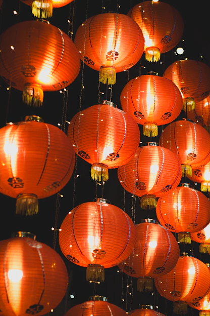 Many glowing red chinese lanterns hanging at night