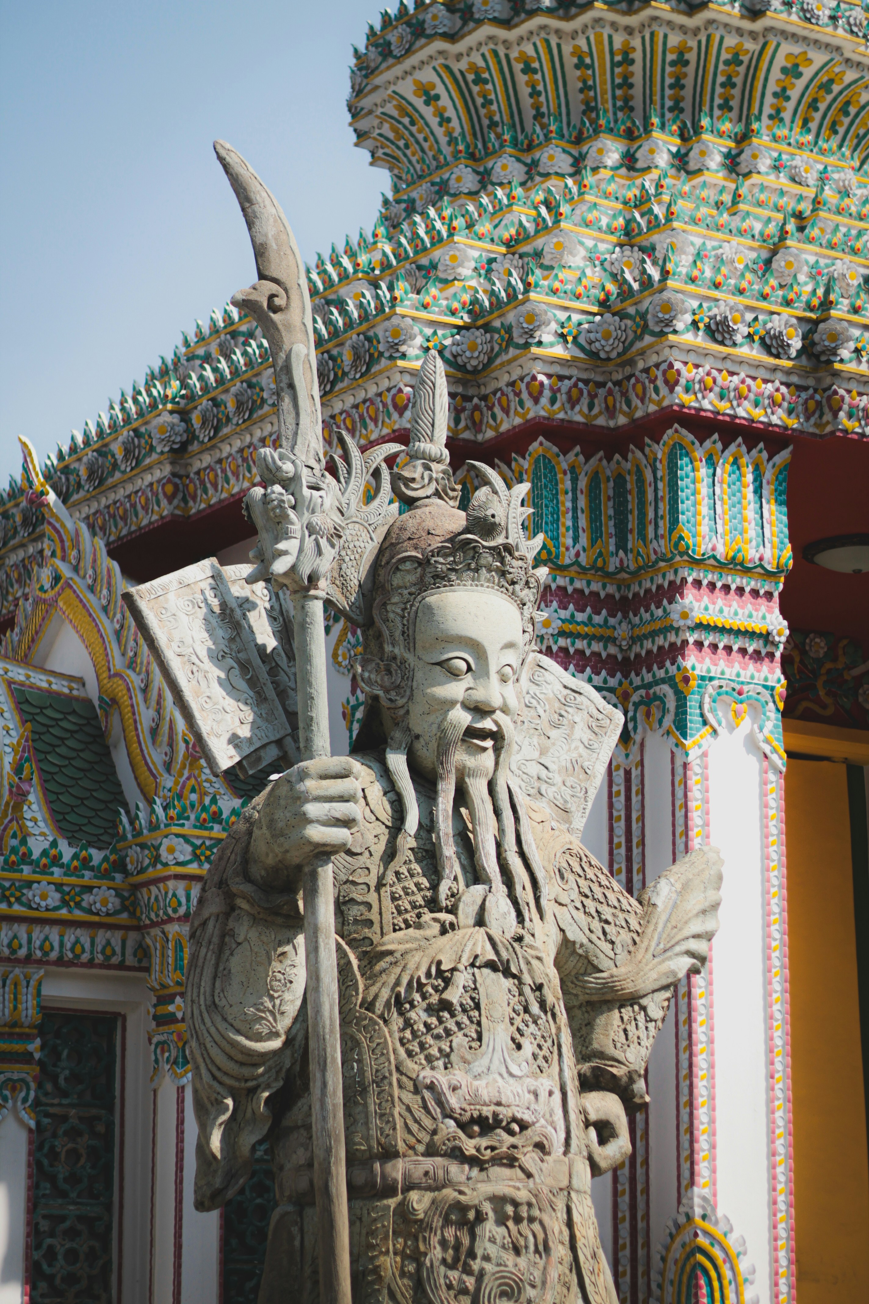 Stone warrior statue guards ornate temple building