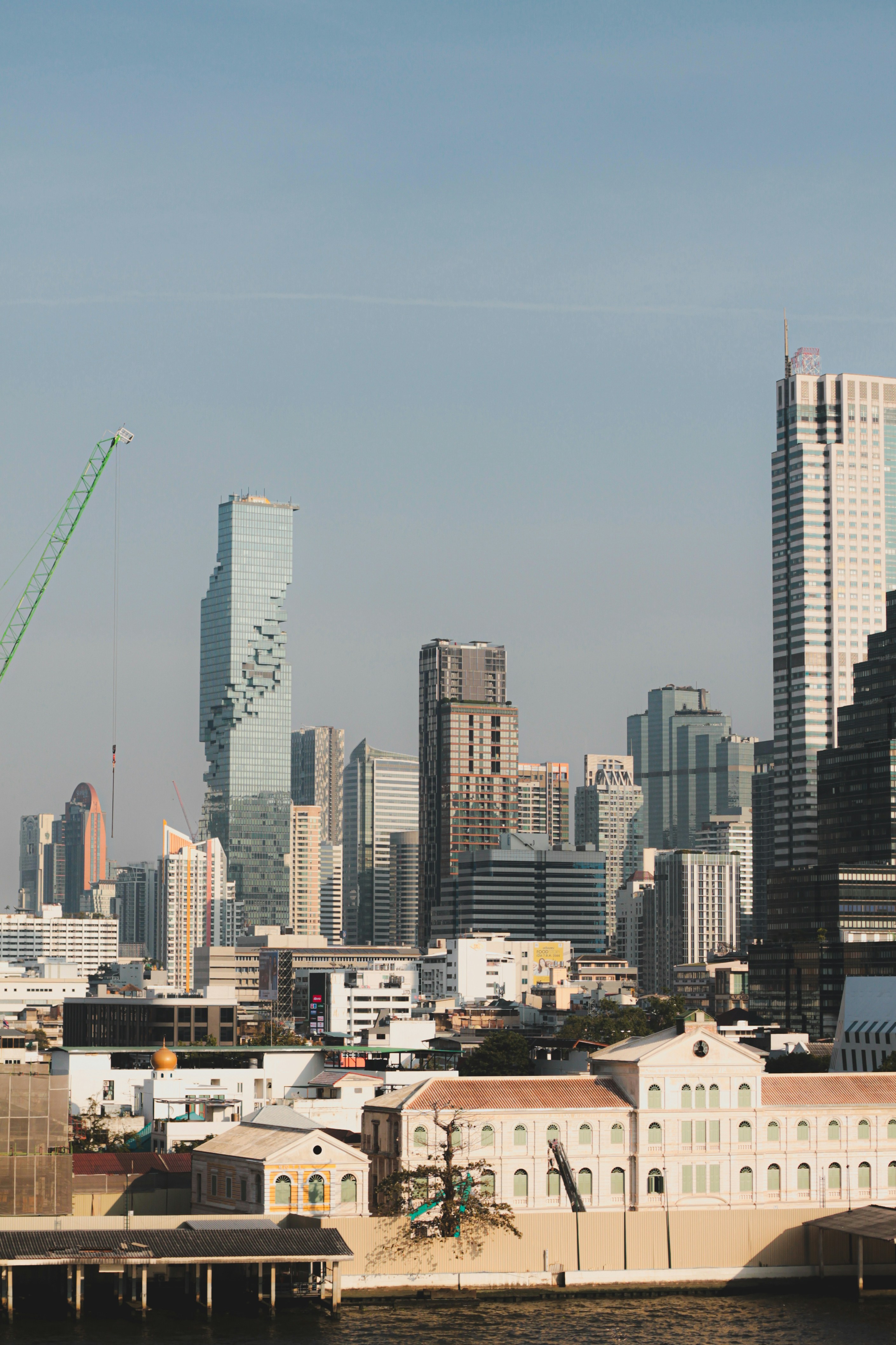 Paesaggio urbano moderno con edifici alti e strutture lungo il fiume.