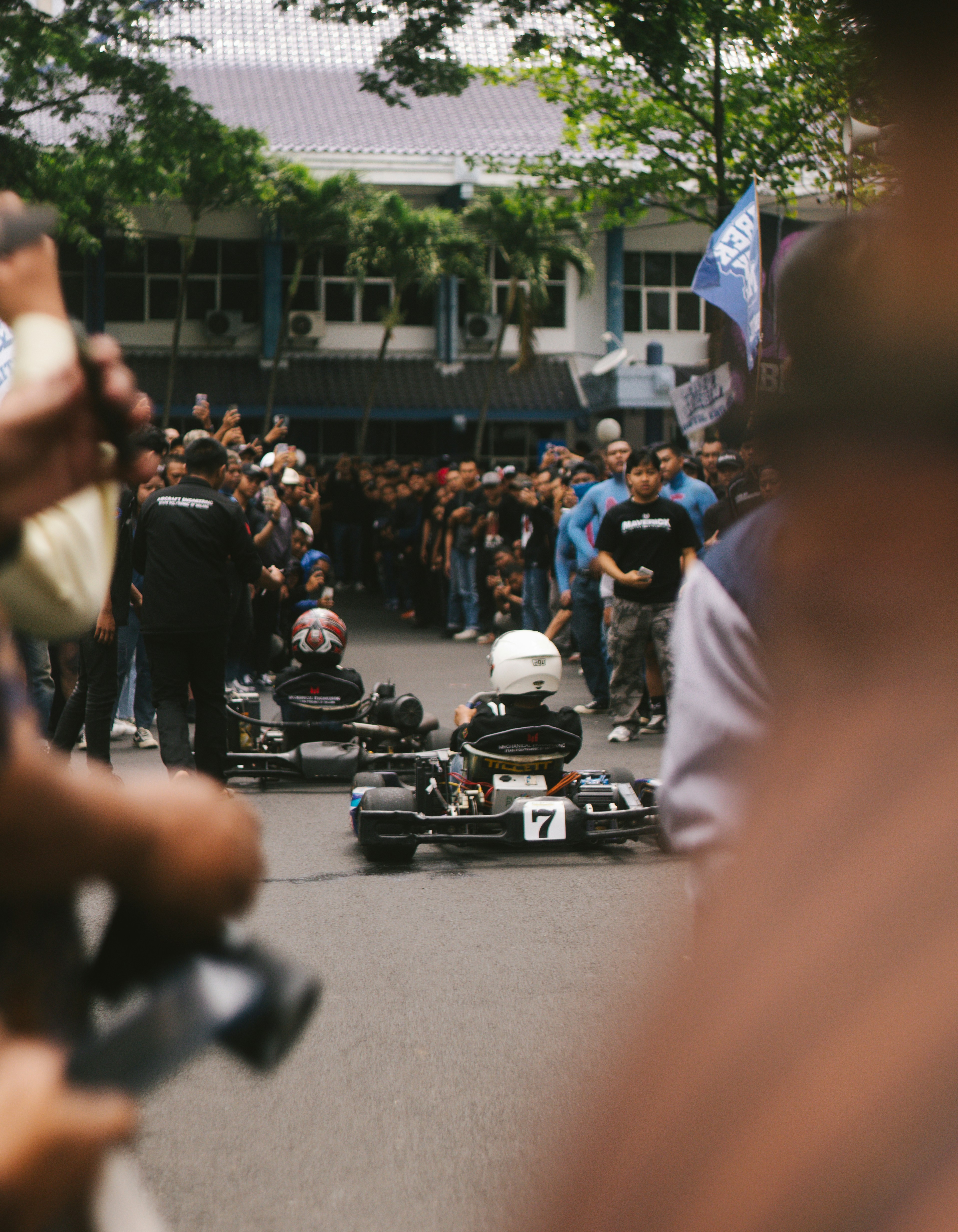 Go-Karts reihen sich auf einer Straße auf, vor den Augen der Zuschauer.
