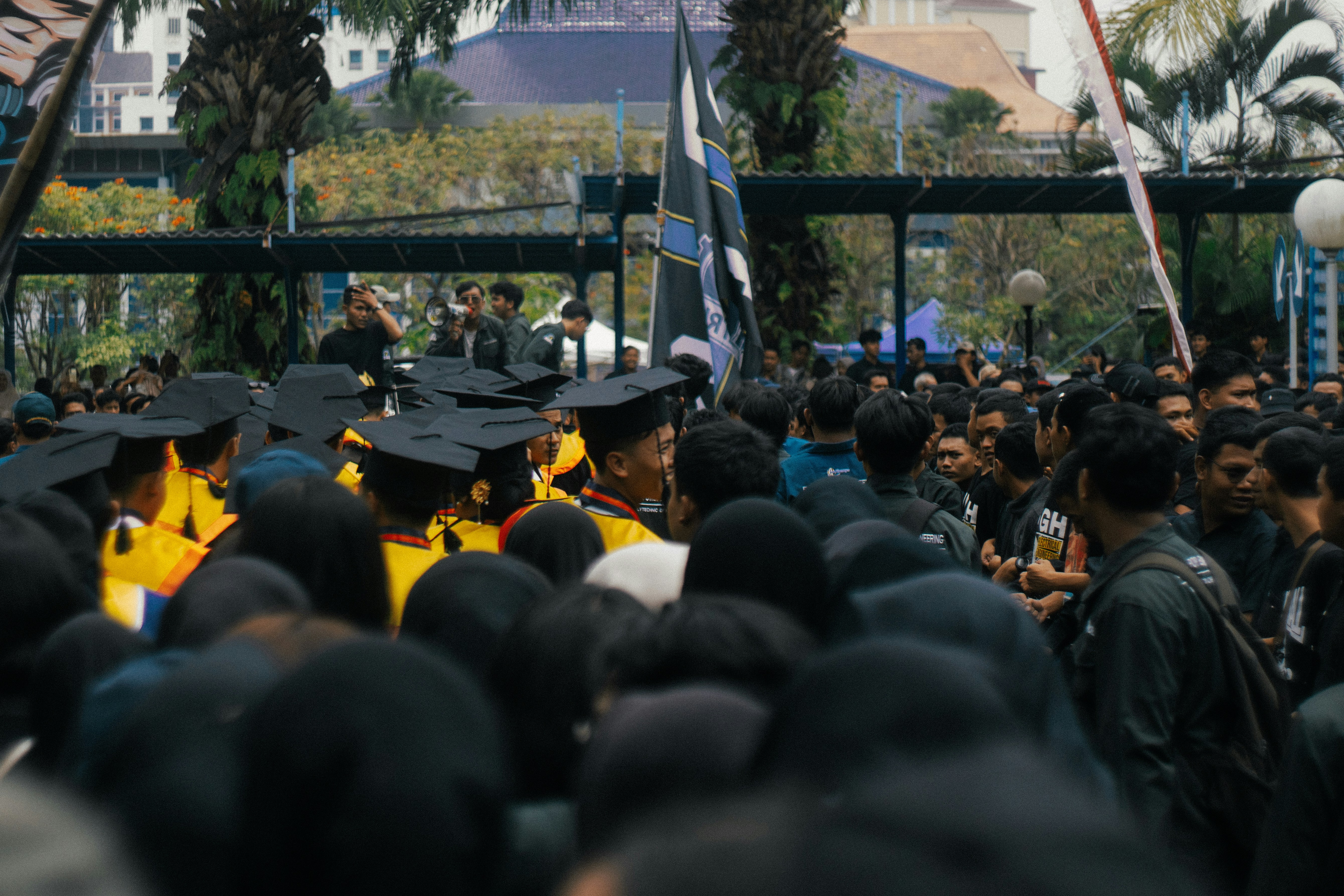 Graduates in caps and gowns gathered outdoors