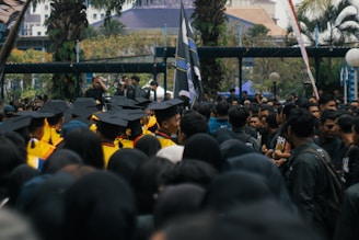 Graduates in caps and gowns gathered outdoors