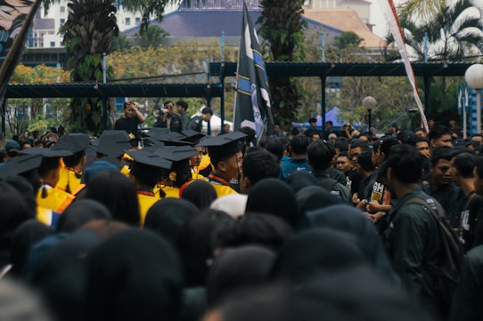 Graduates in caps and gowns gathered outdoors