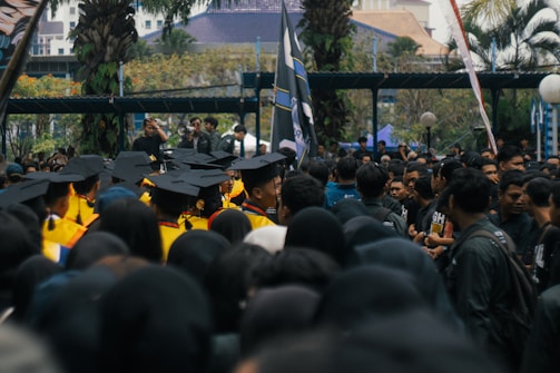 Graduates in caps and gowns gathered outdoors