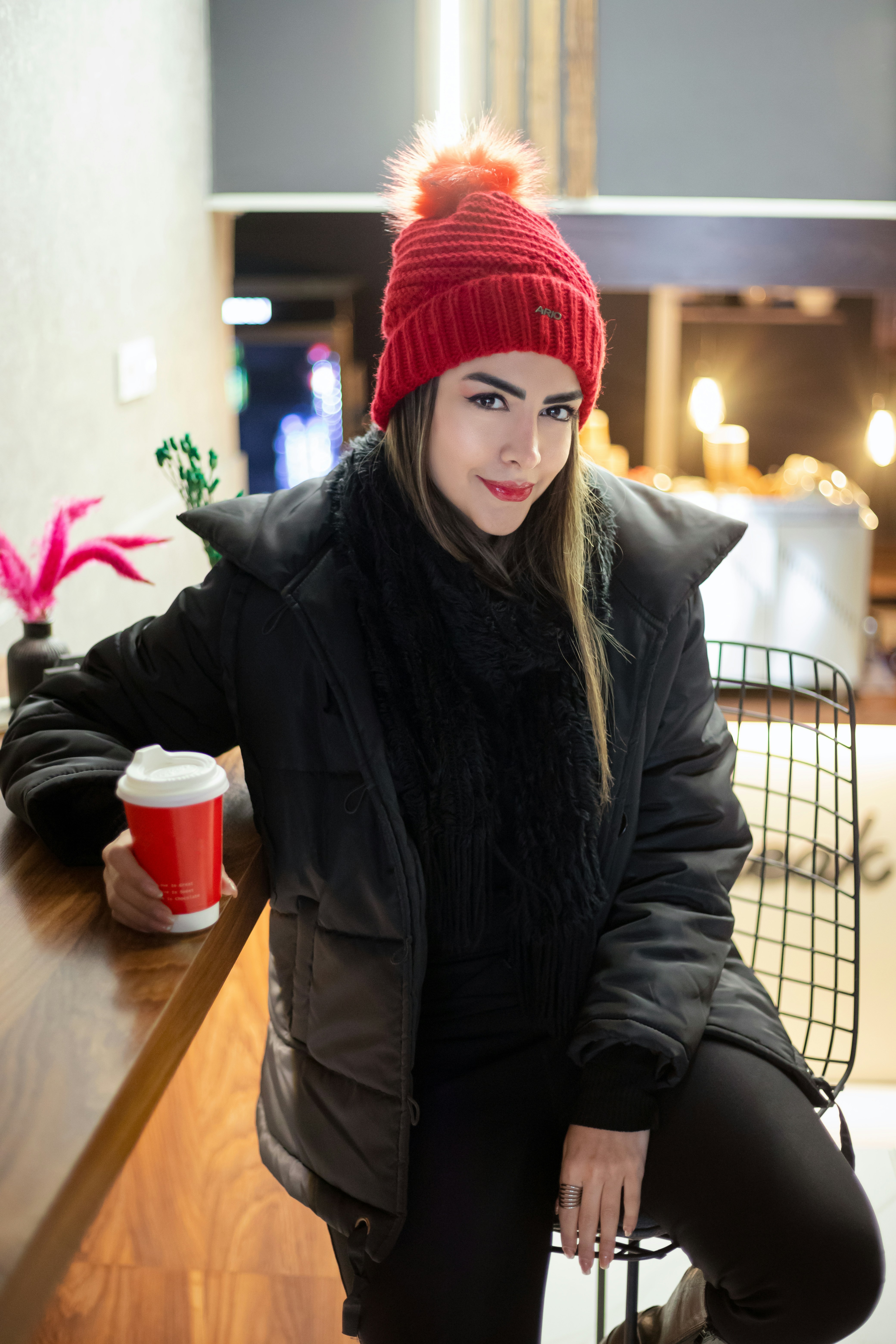 A woman in a red hat holding a coffee cup