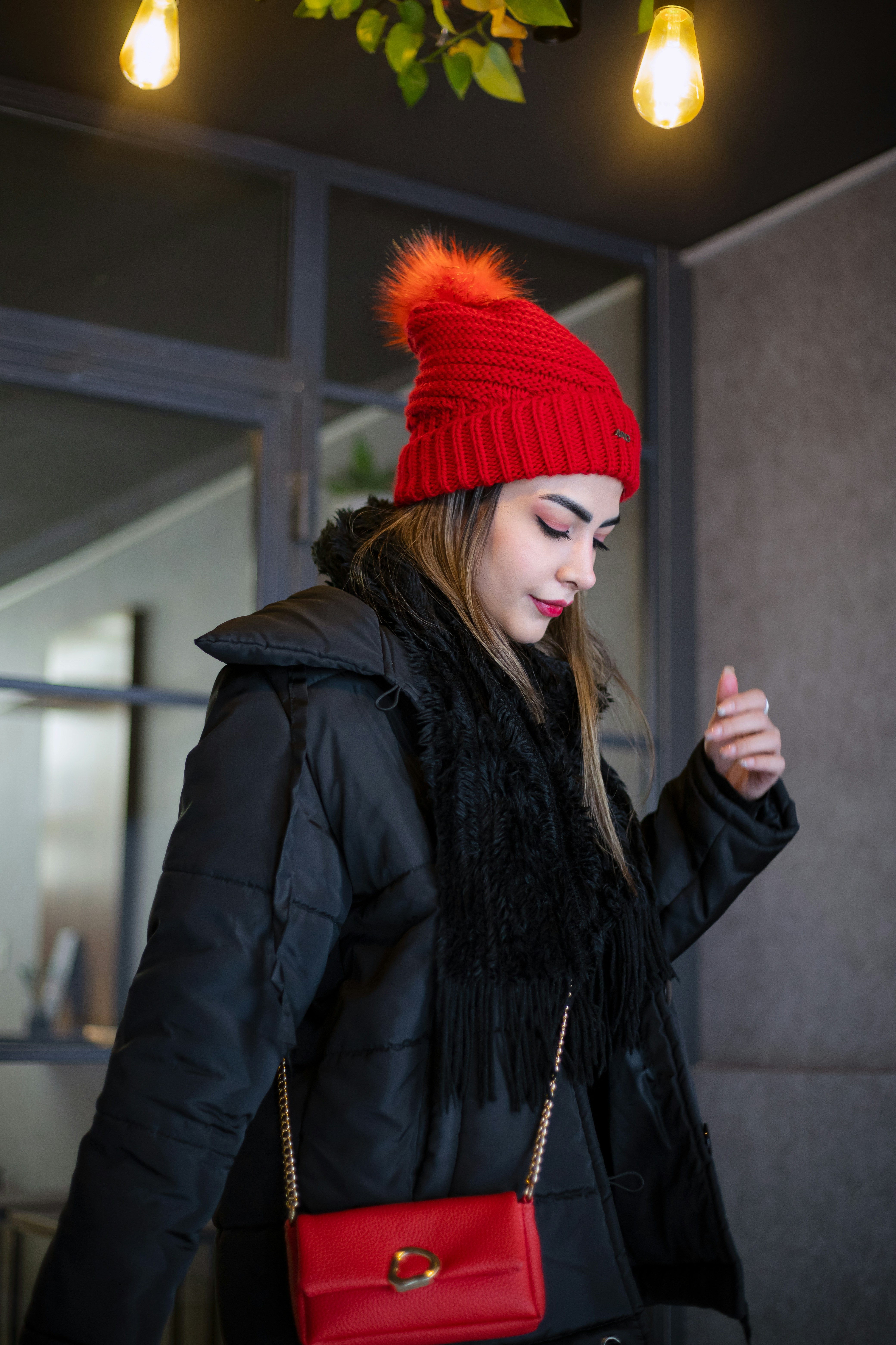 Femme en chapeau rouge et veste noire avec sac à main rouge