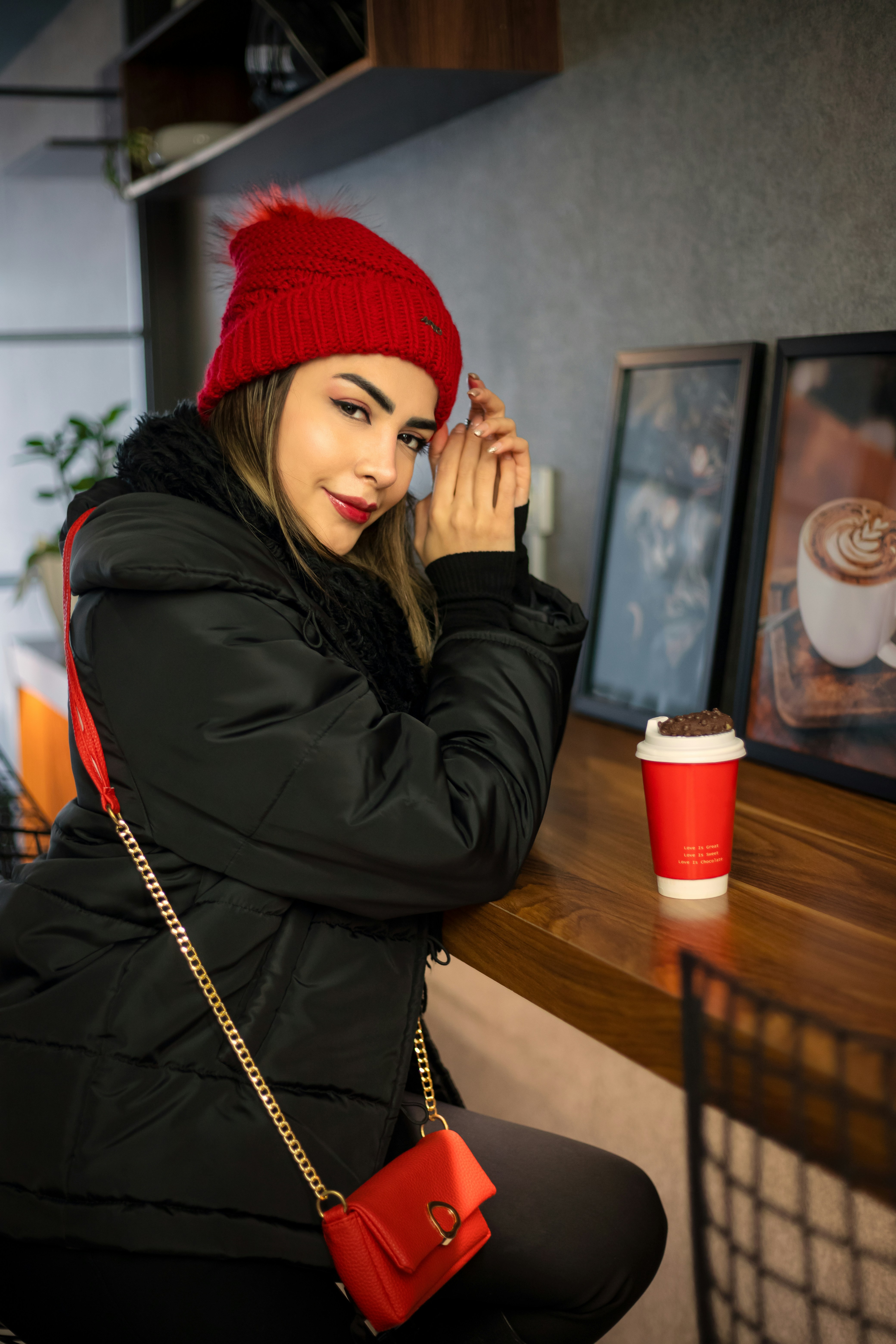 Woman in red hat and black coat at cafe