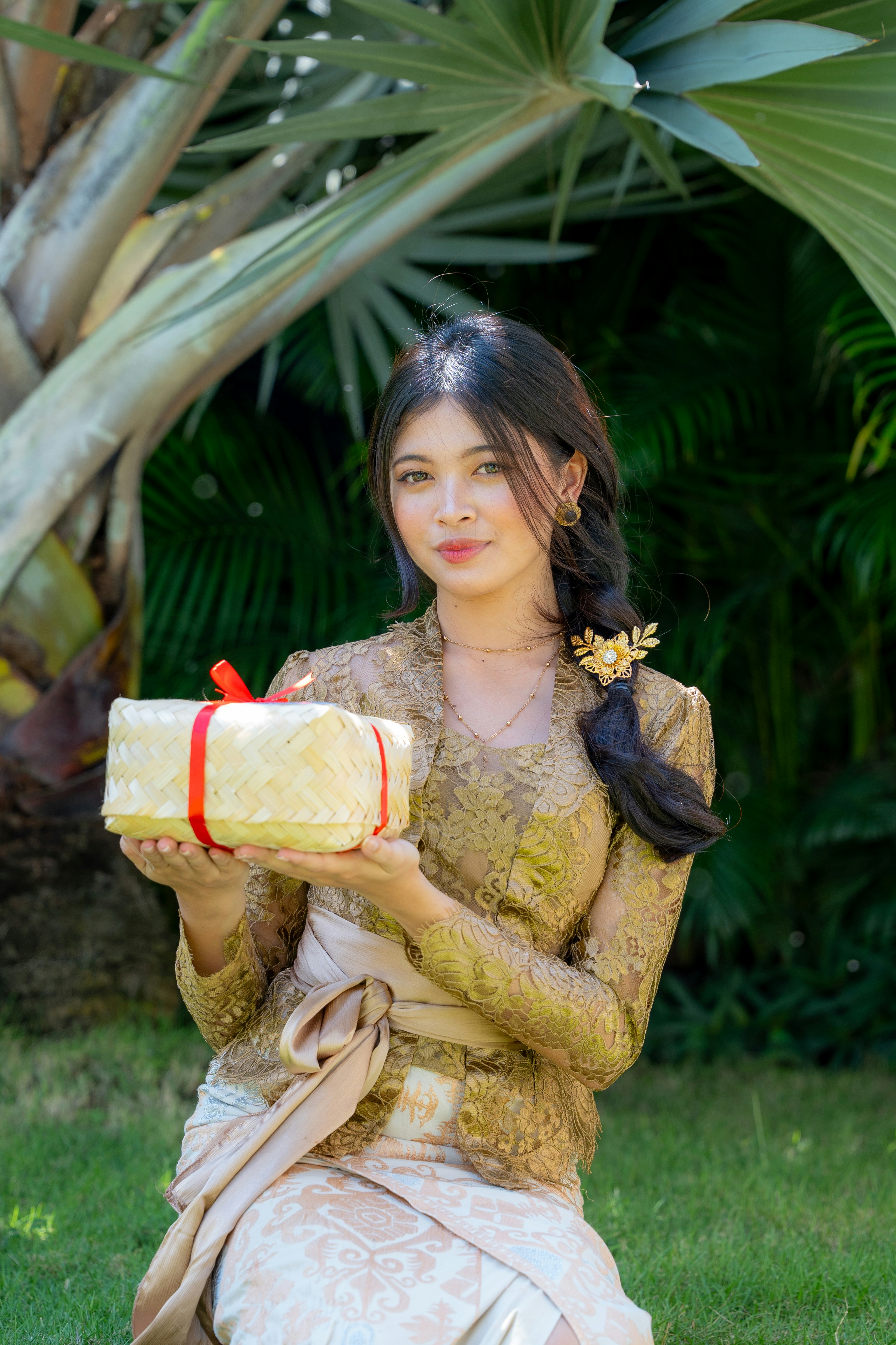Young woman in traditional dress holds a gift.