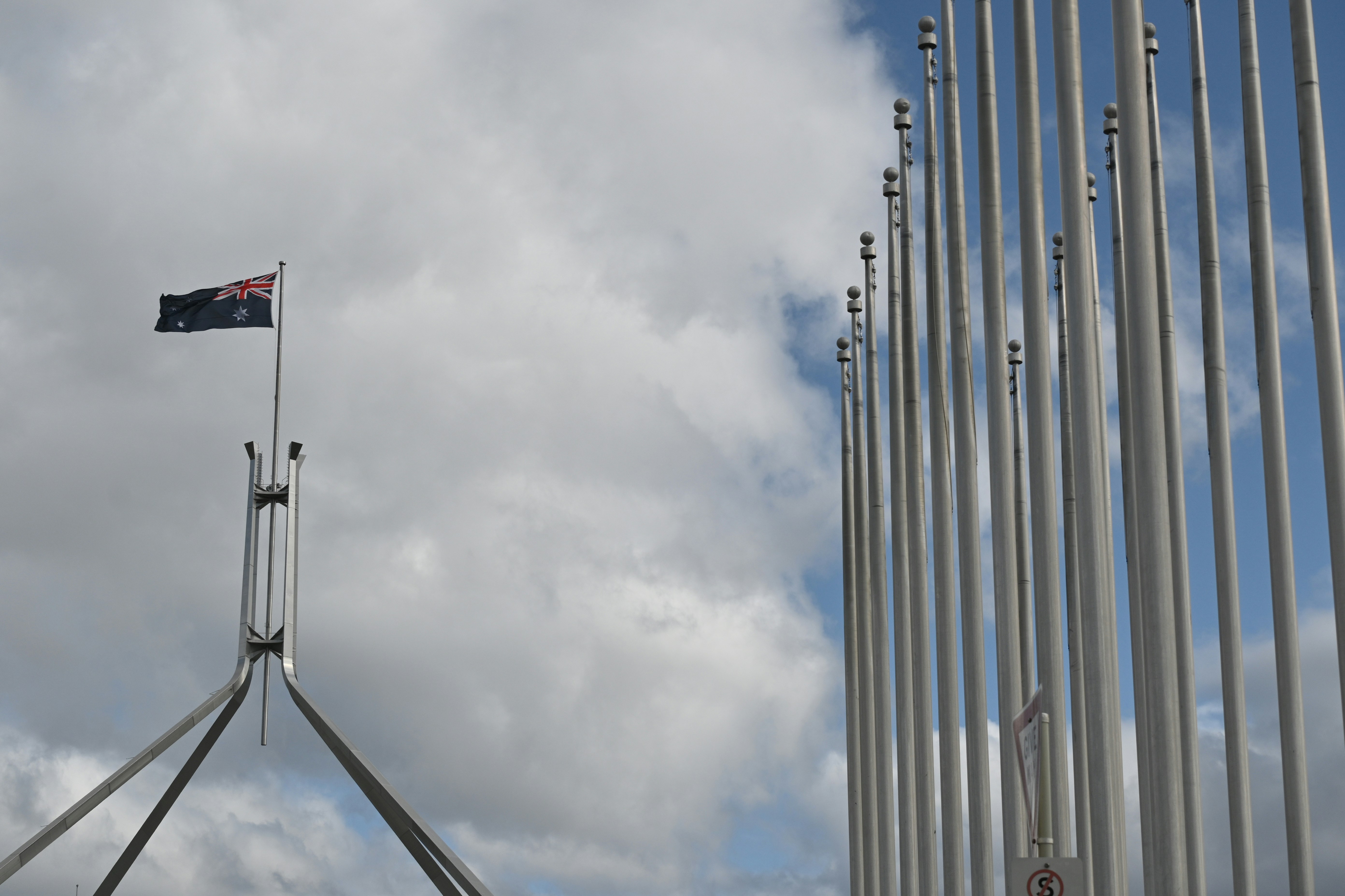 Le drapeau australien flotte près du bâtiment du Parlement et des mâts