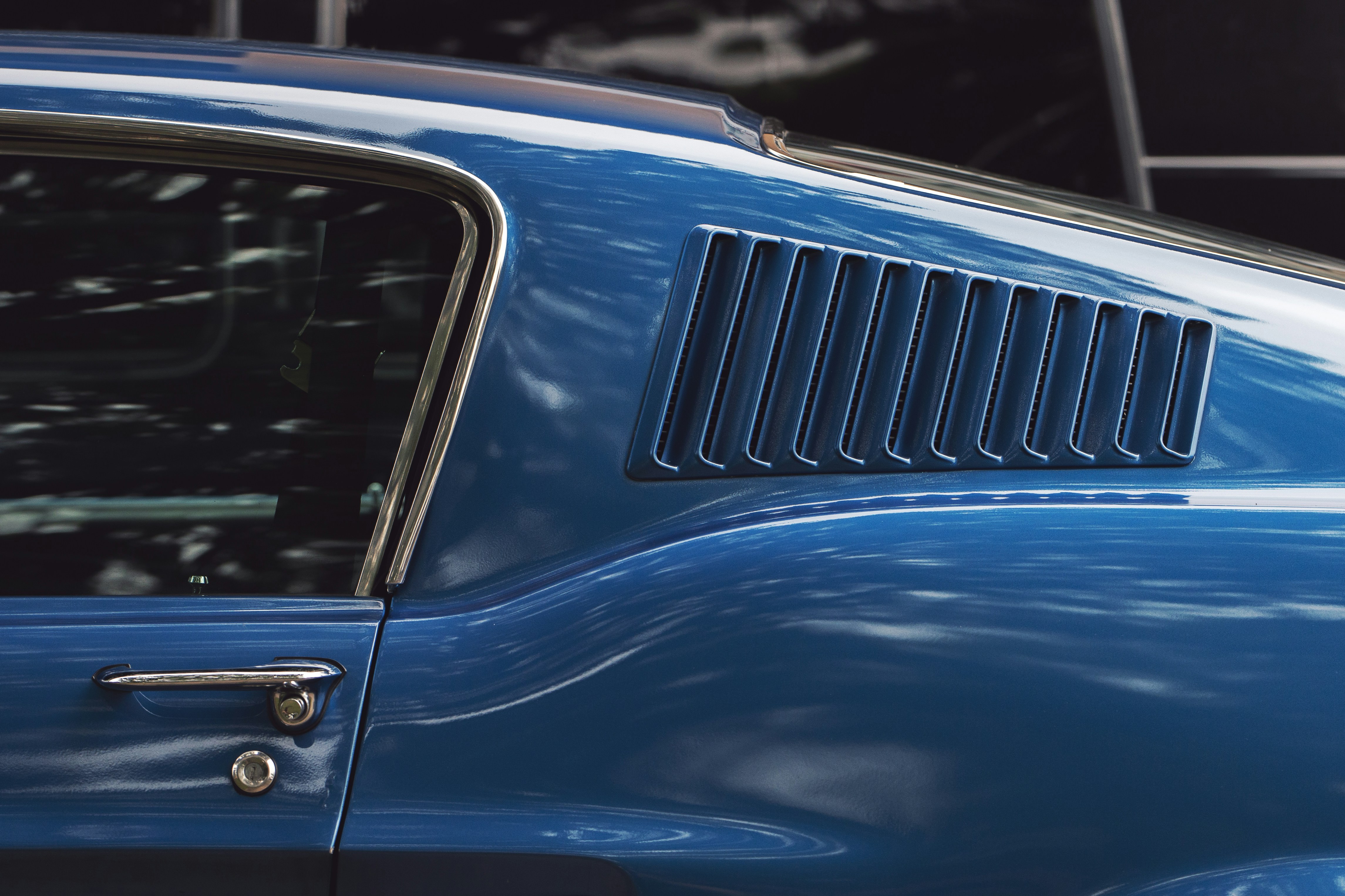 Close-up of a blue vintage car's side vent.