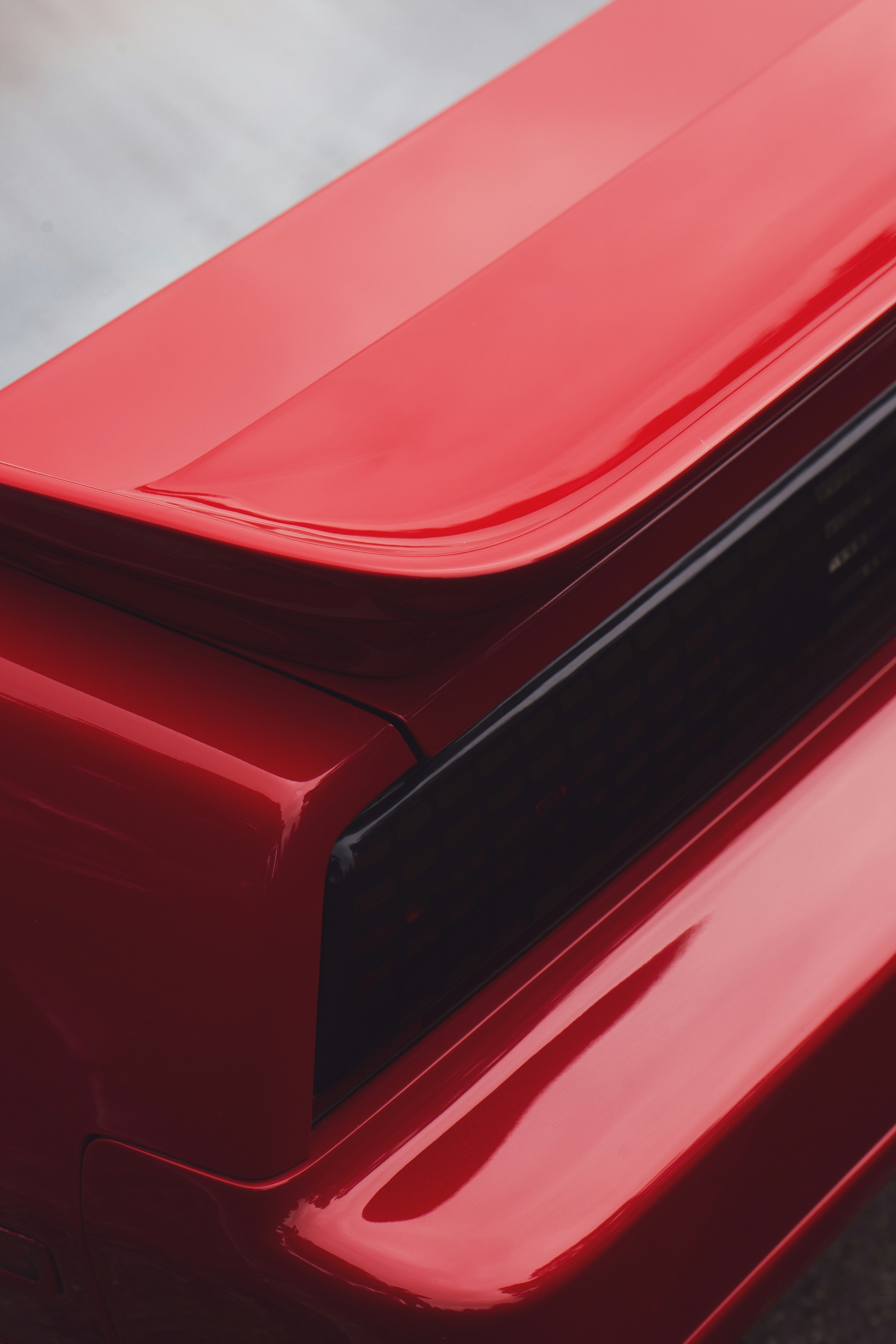 Close-up of a shiny red car spoiler.