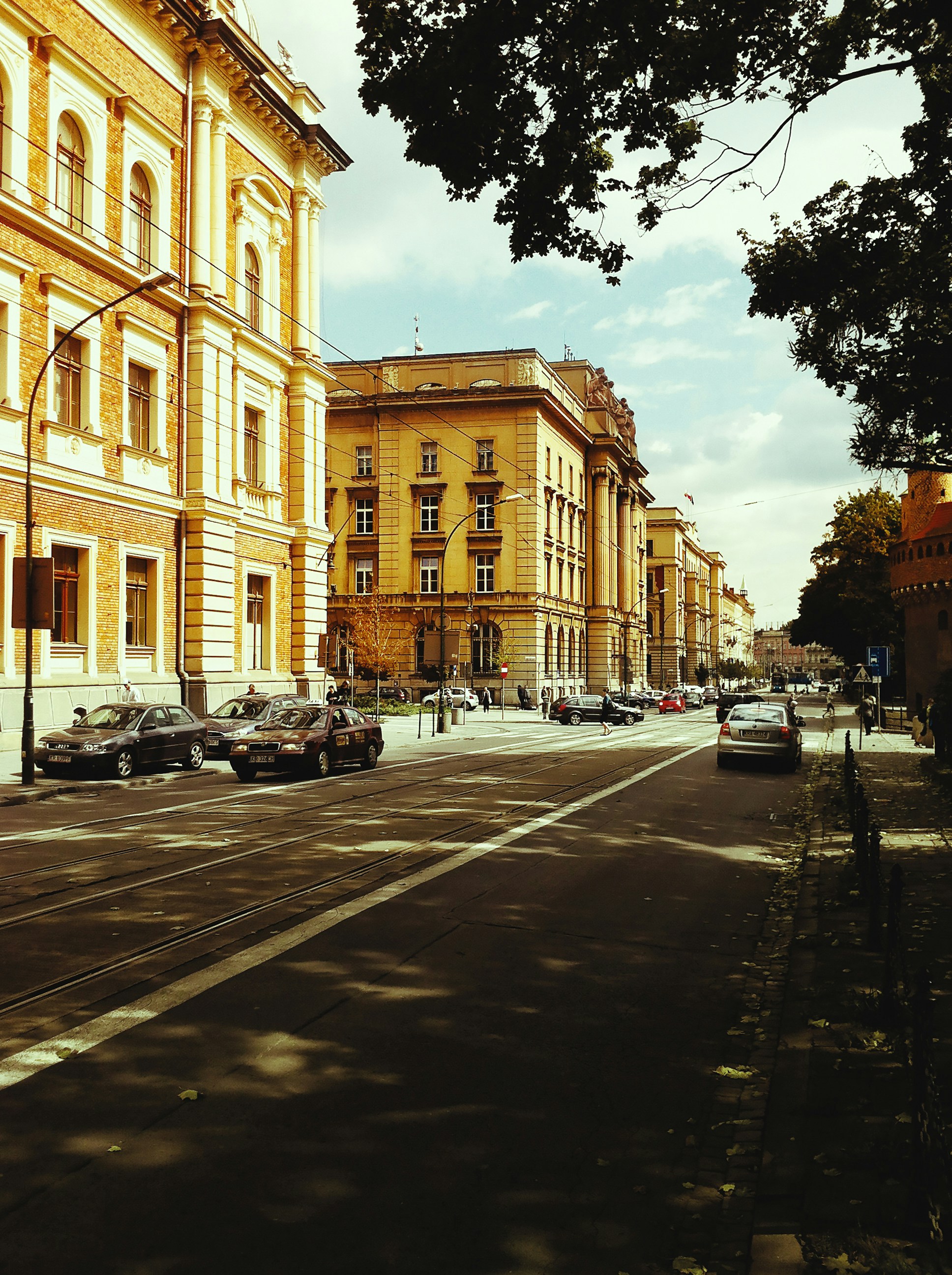 Street view of historic buildings and parked cars
