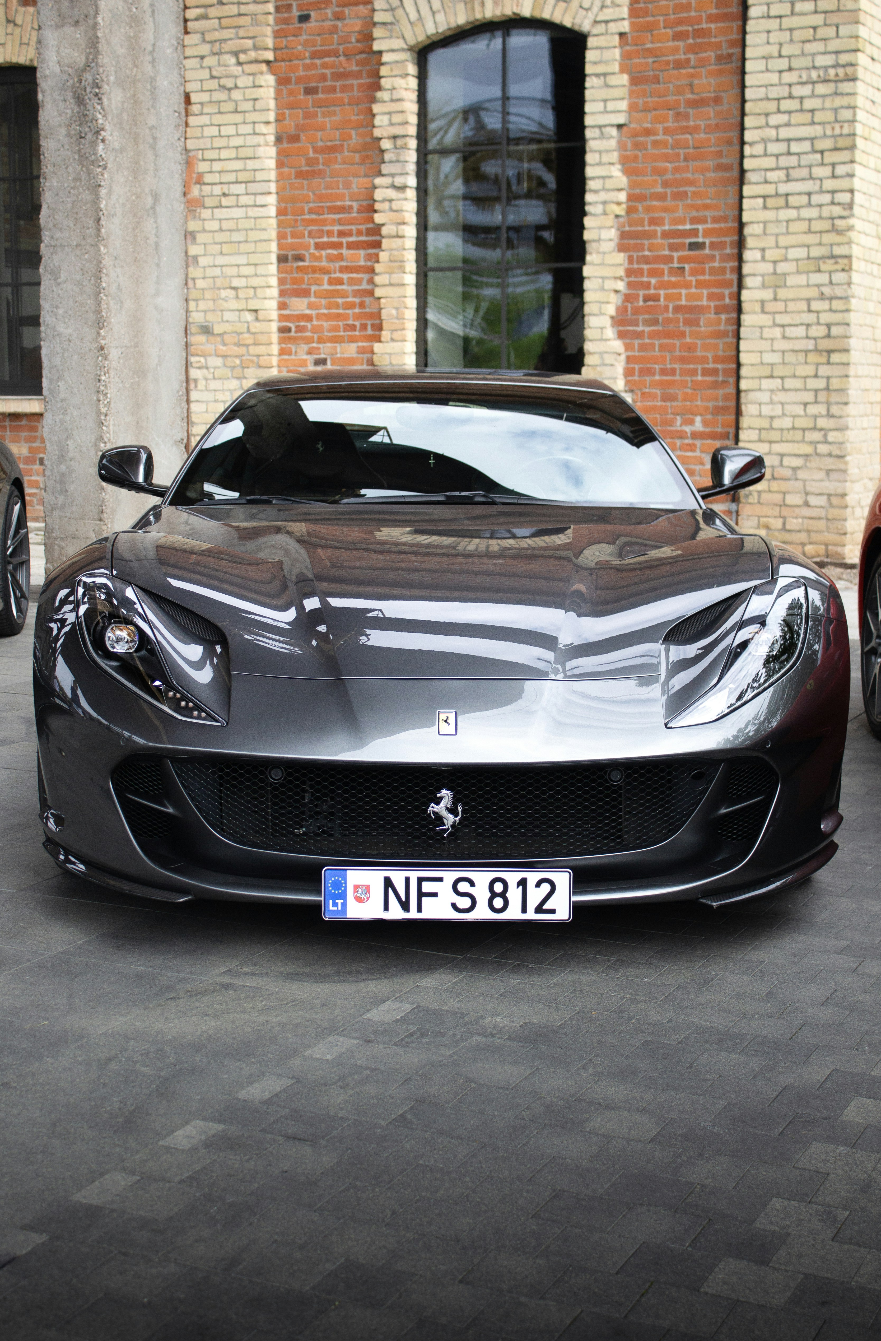 A sleek, dark grey ferrari sports car parked outdoors.