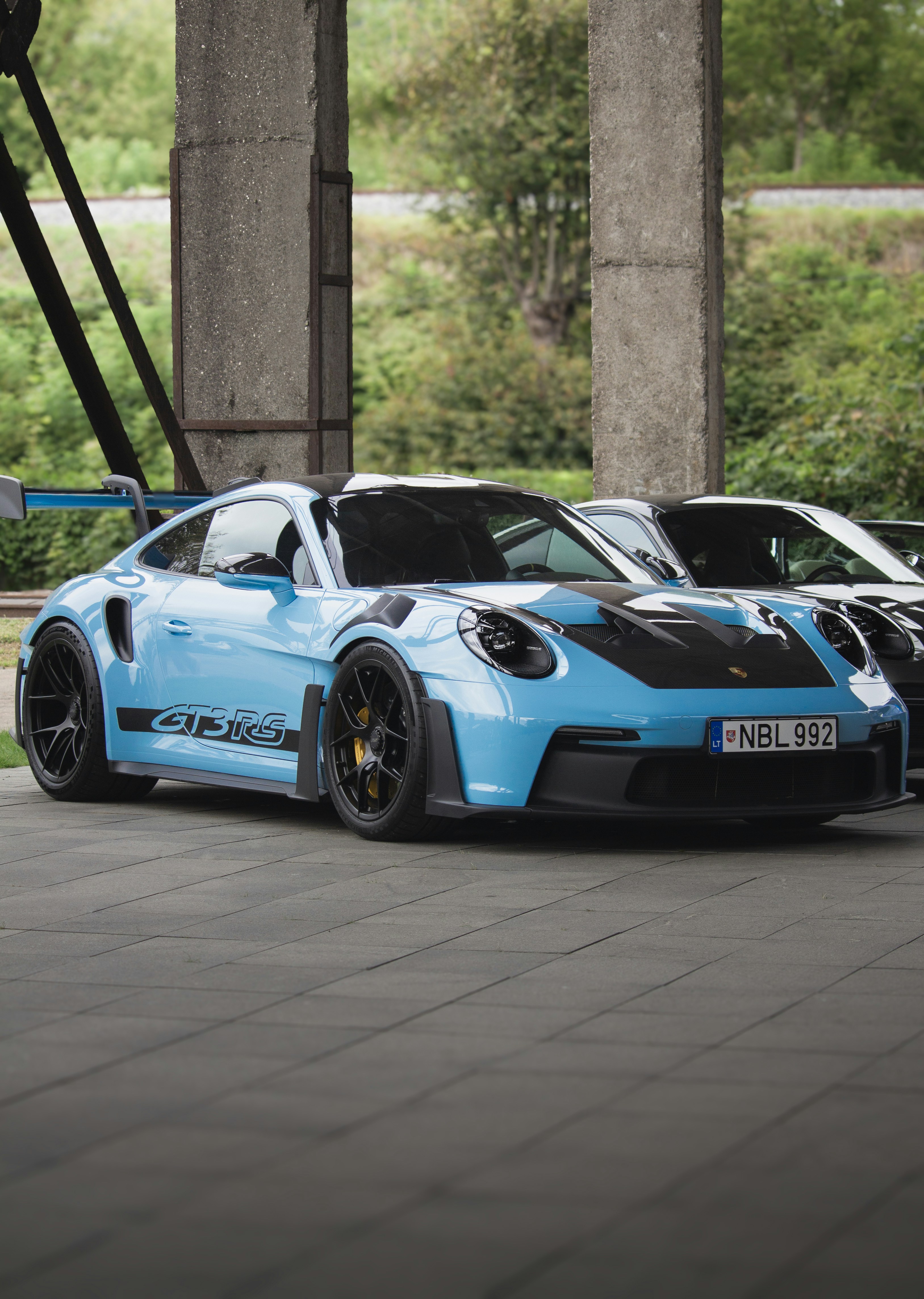 A light blue porsche gt3 rs parked outdoors.