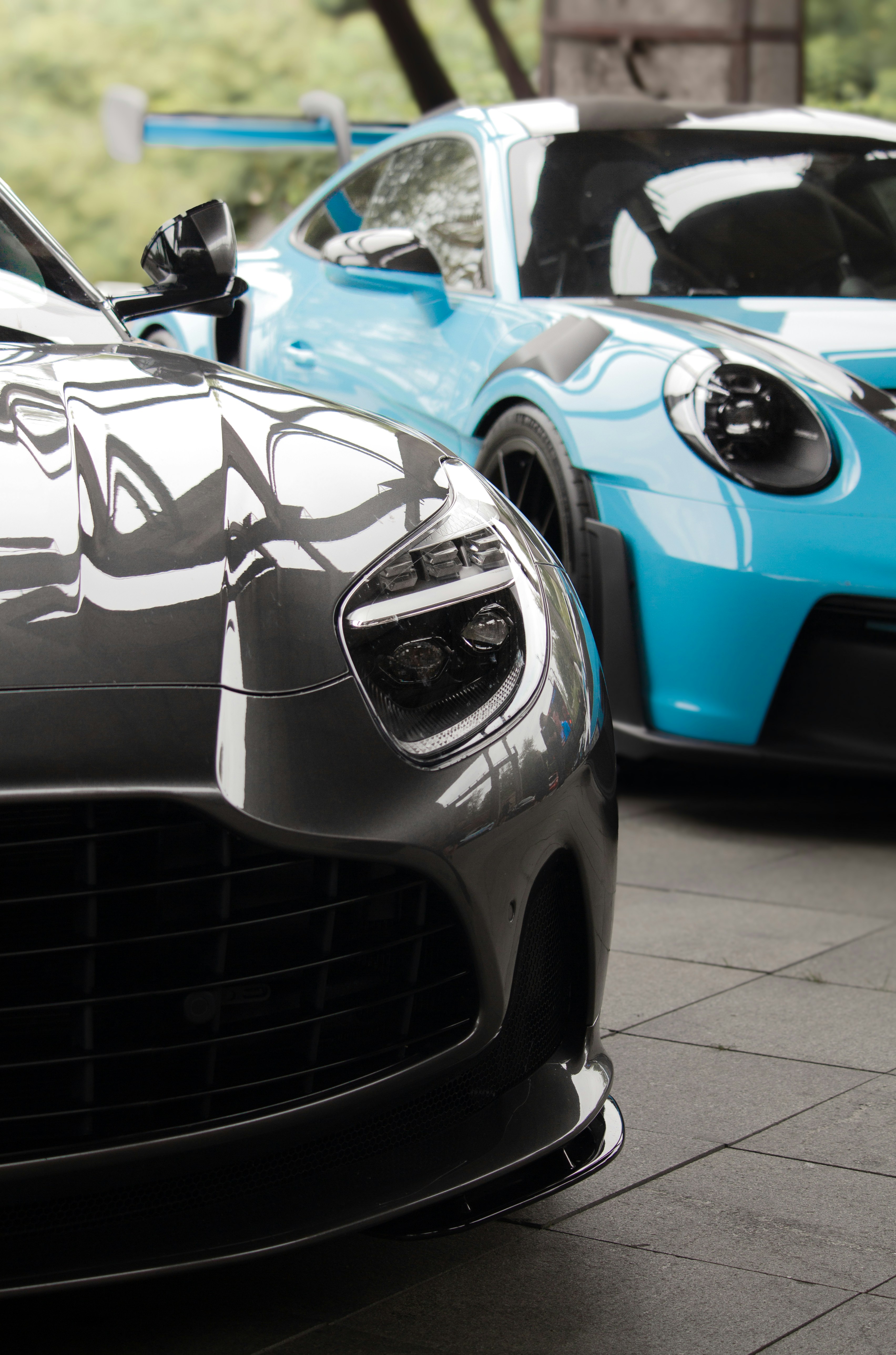 Two sports cars, one gray and one blue.