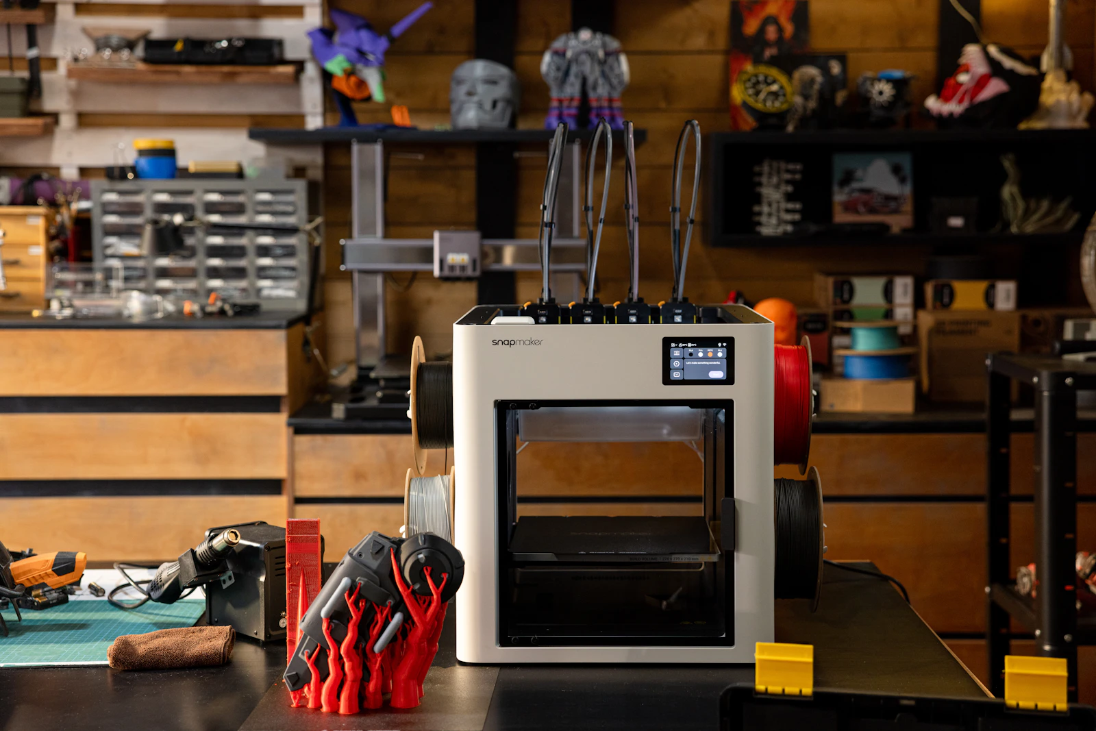 Desktop 3D printer with tools and printed parts in a workshop
