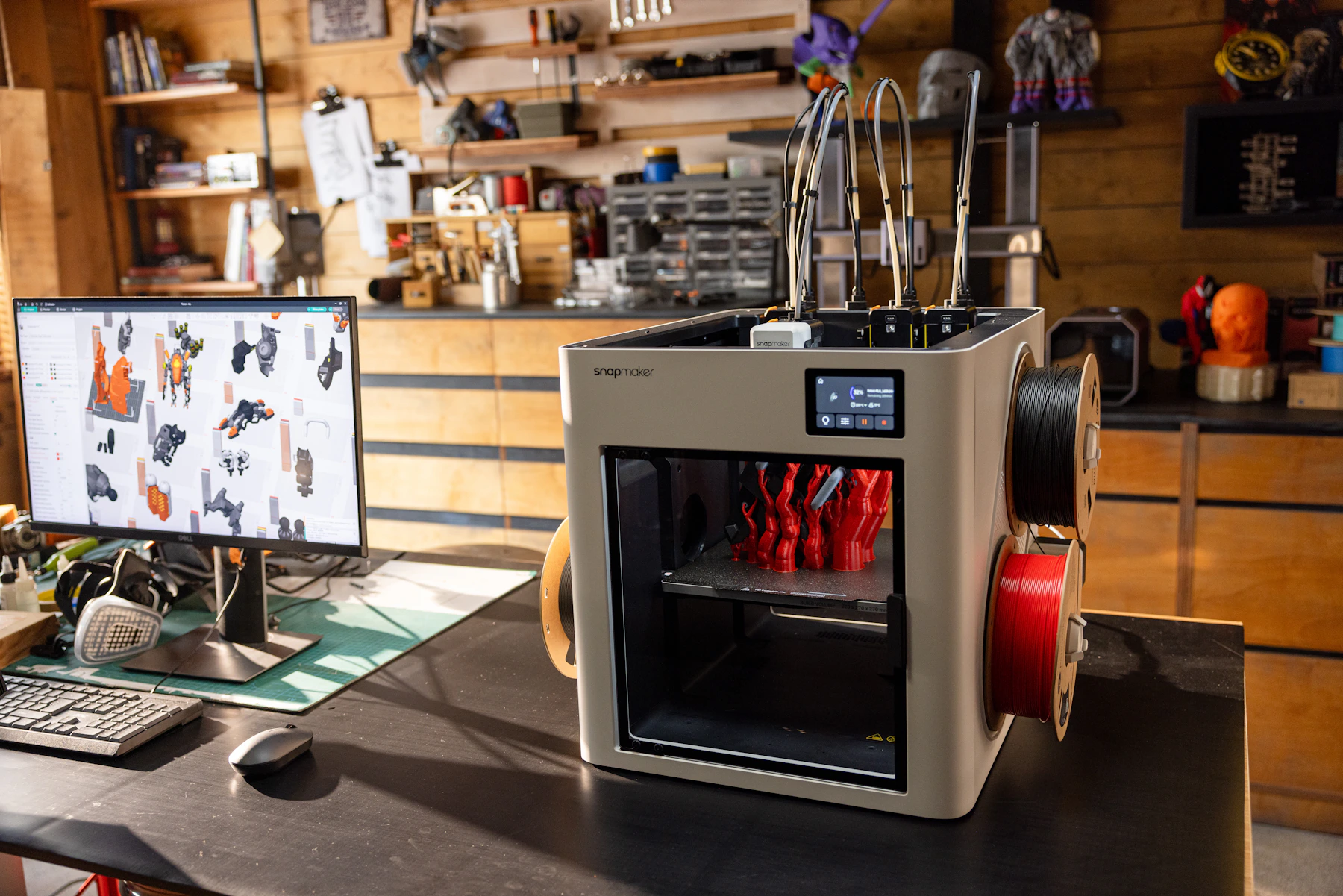 Desktop 3D printer producing red parts in a working studio