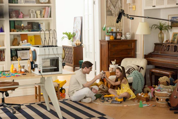 Father and daughter playing with toys on floor
