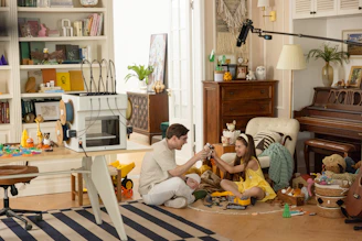 Father and daughter playing with toys on floor