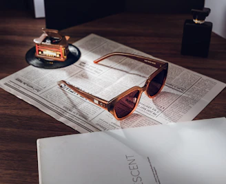 Stylish sunglasses resting on newspaper with vintage gramophone.