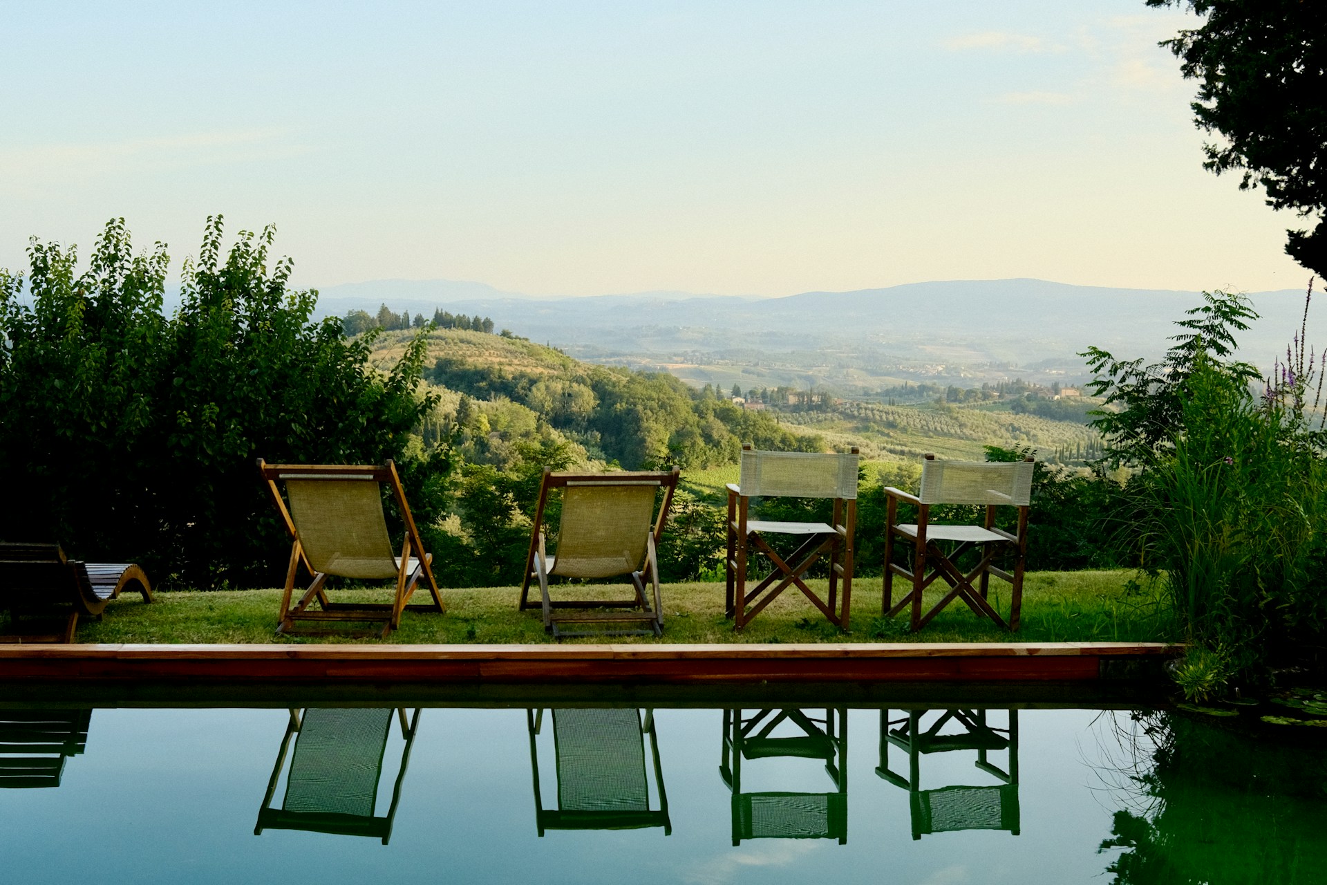 Four chairs by a pool overlooking rolling hills