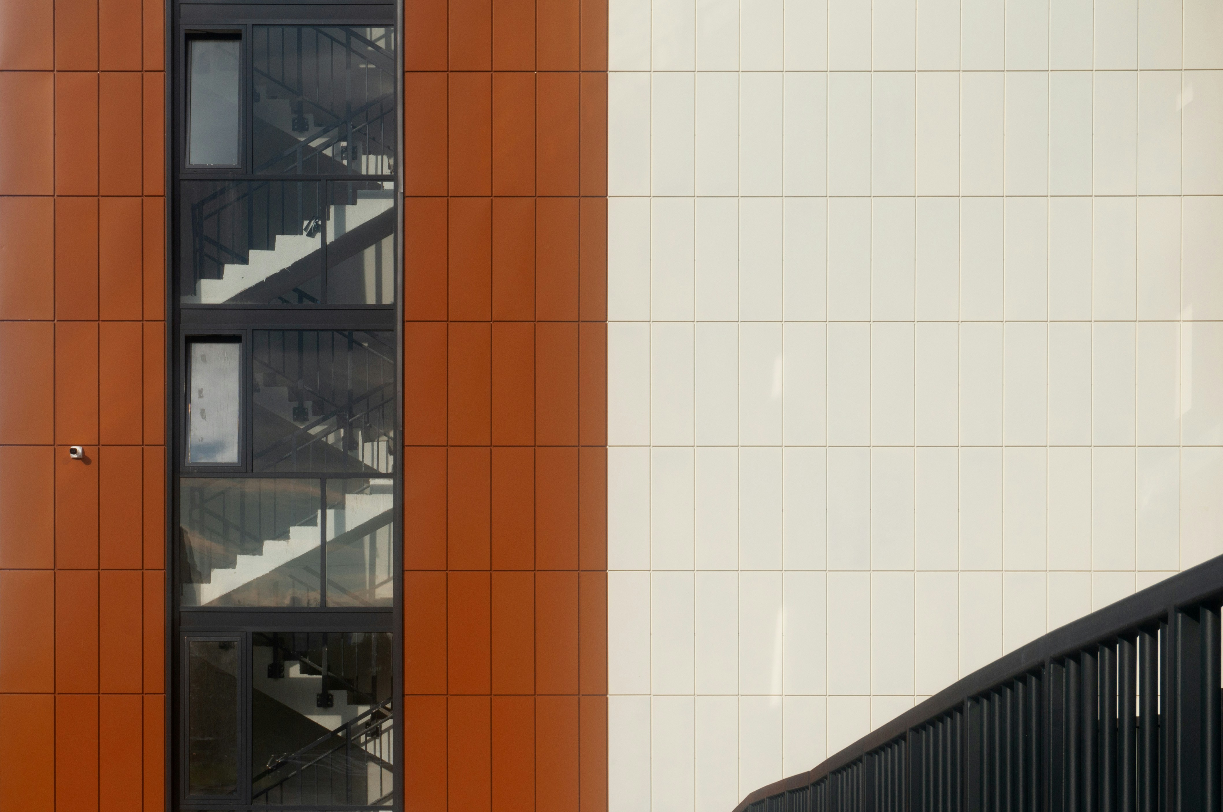 金属製の階段と窓を備えたモダンな建物の外観。