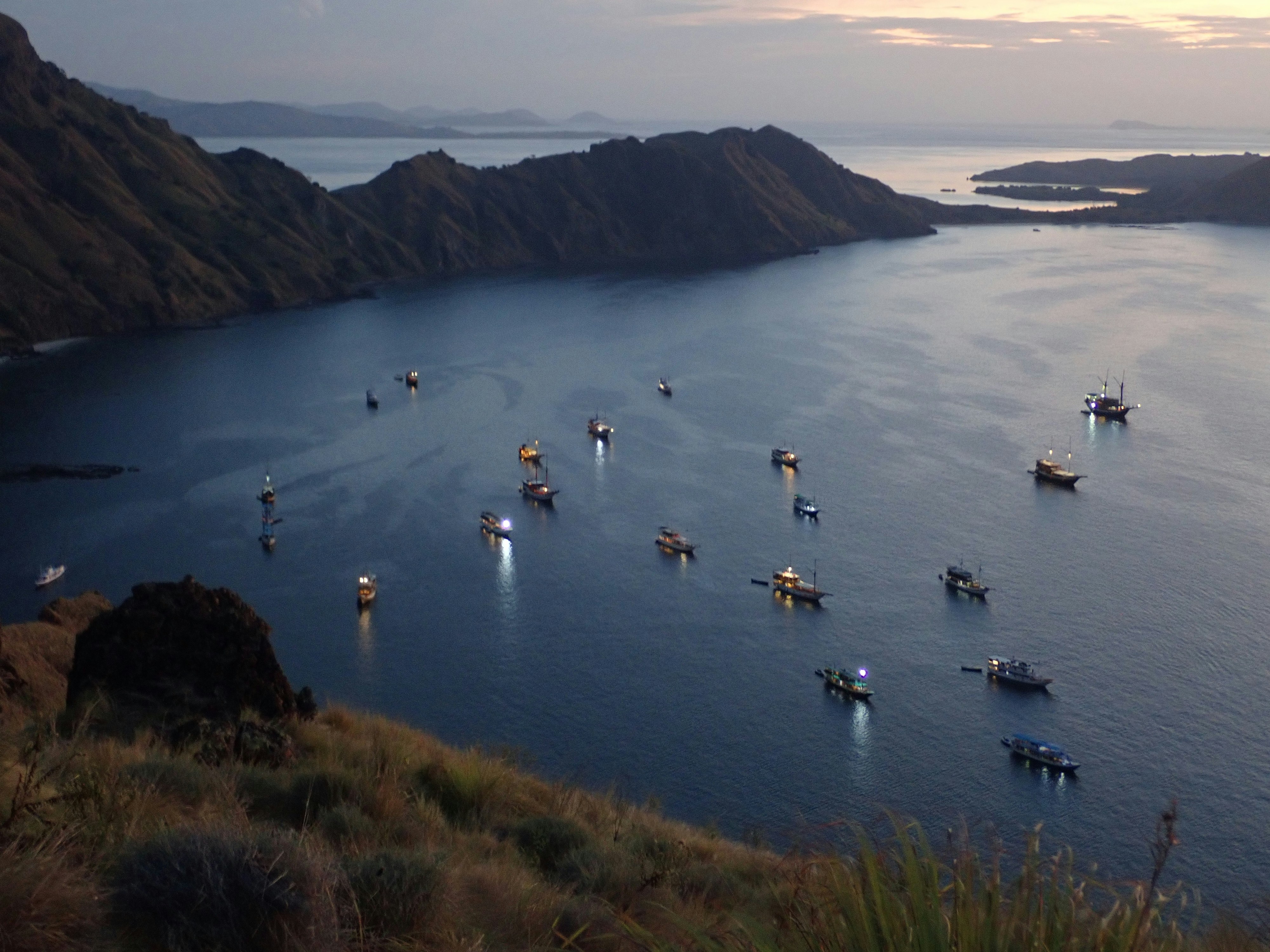 Boats anchored in a calm bay at dusk
