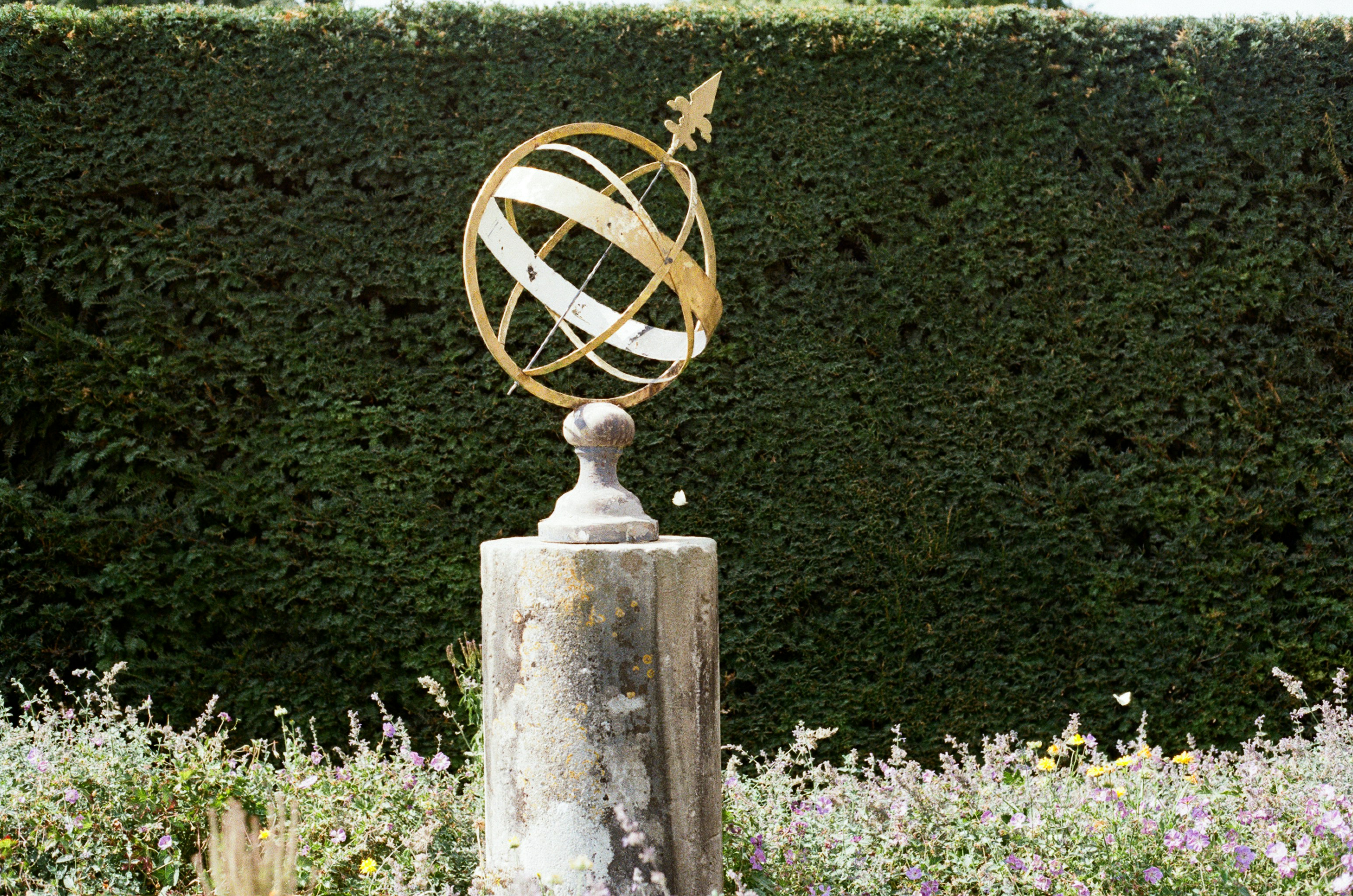 An ornate armillary sphere sundial on a wooden post. photo – Free ...