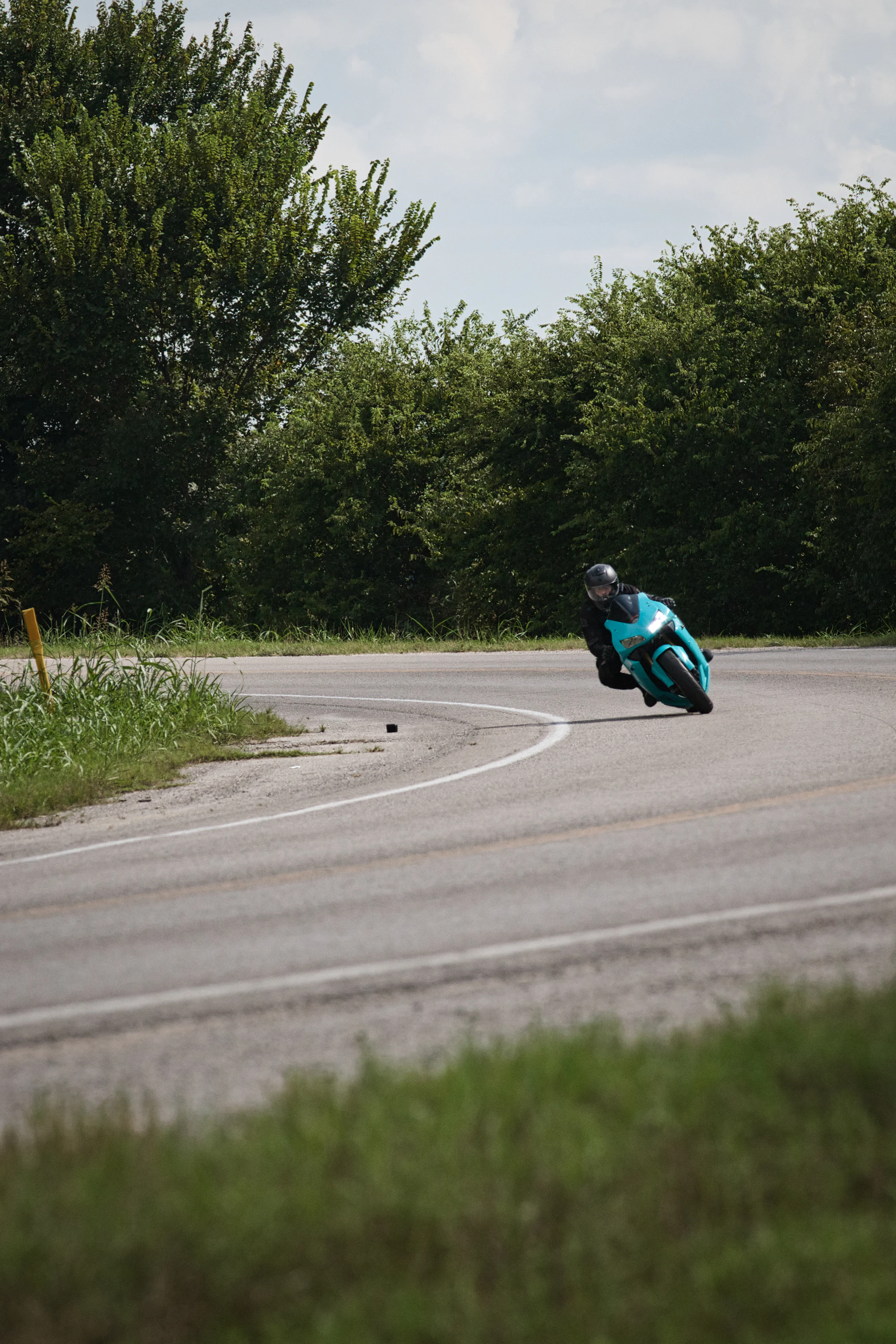 Motorcyclist leaning deep into a curve on a twisty road