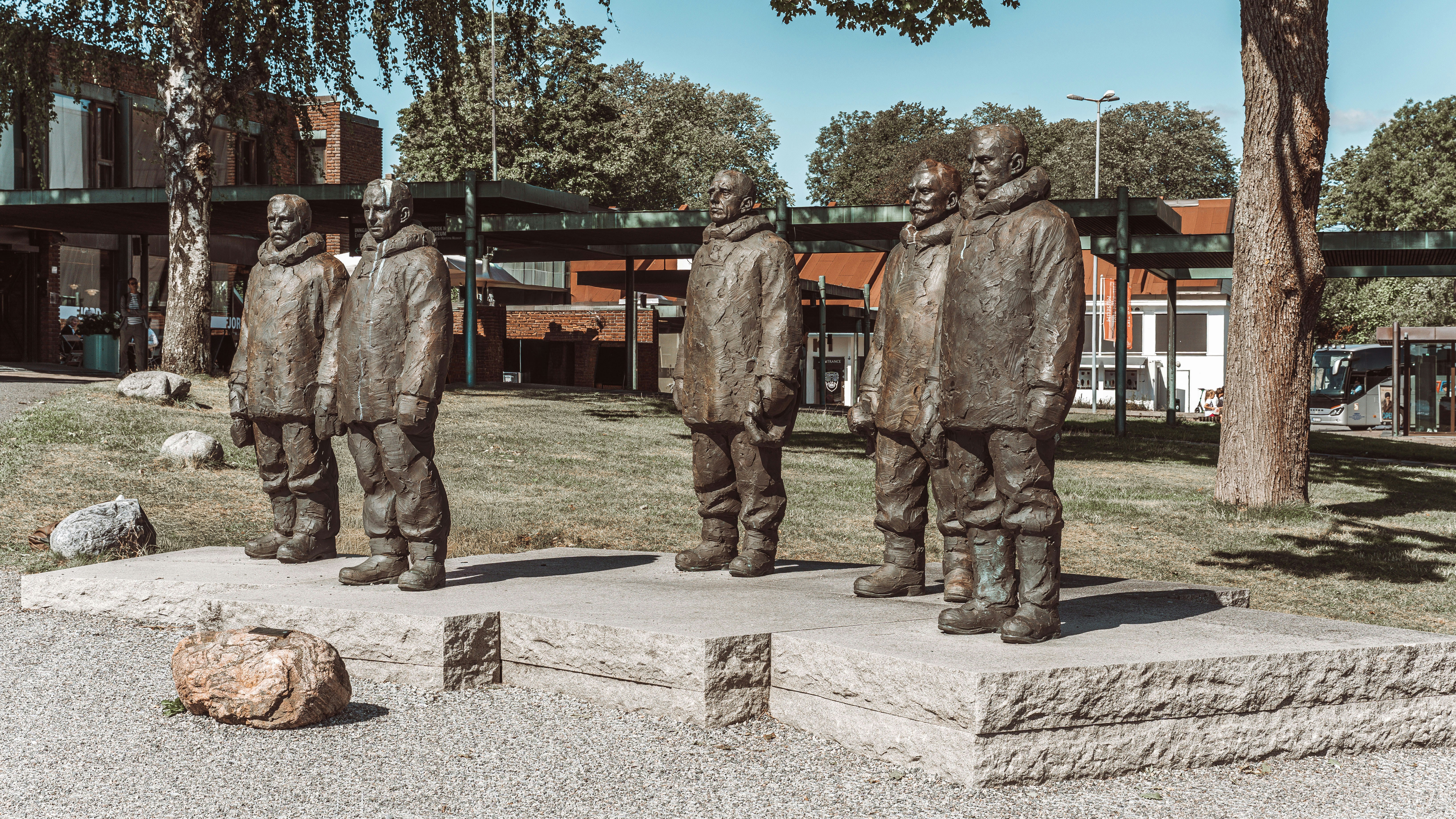 Bronze statues of six men standing on a pedestal.
