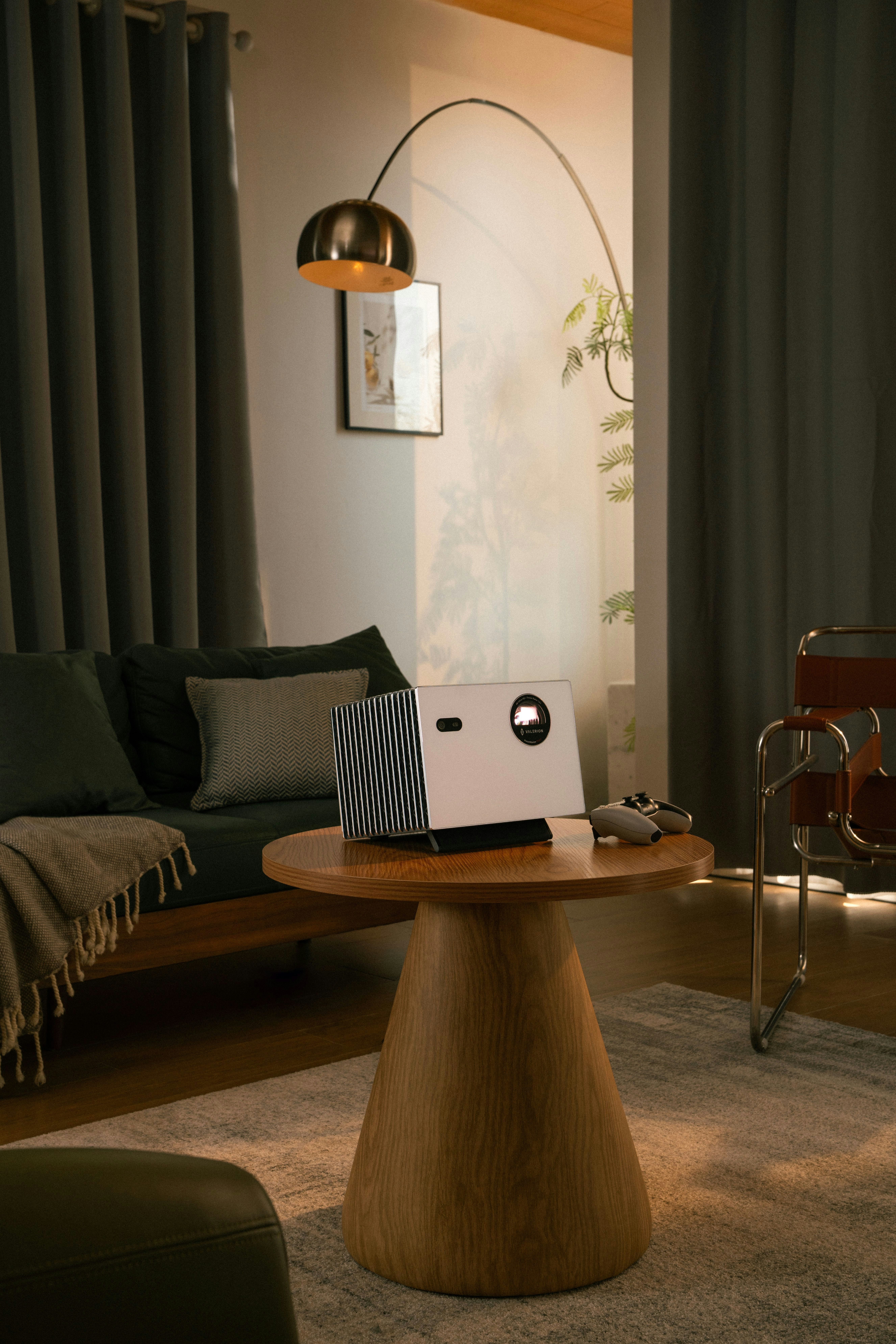 Modern projector on a wooden table in living room.