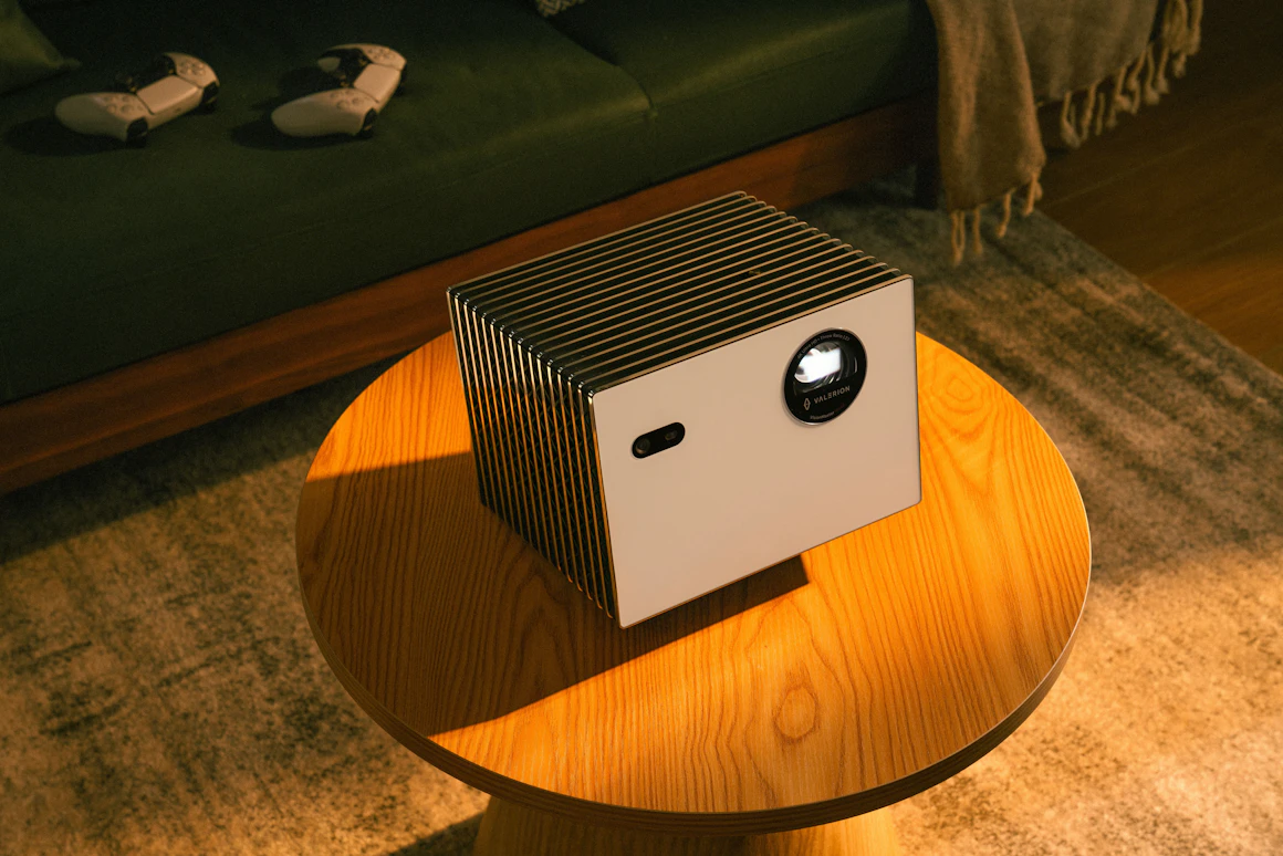 Premium compact projector on a coffee table in a modern home theater setting