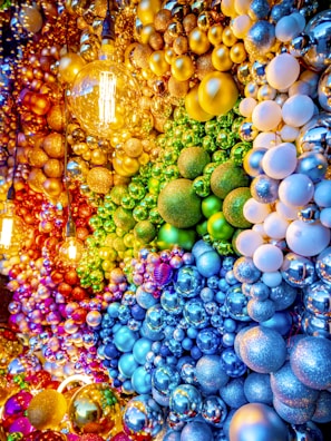 Colorful christmas ornaments arranged in a rainbow pattern.