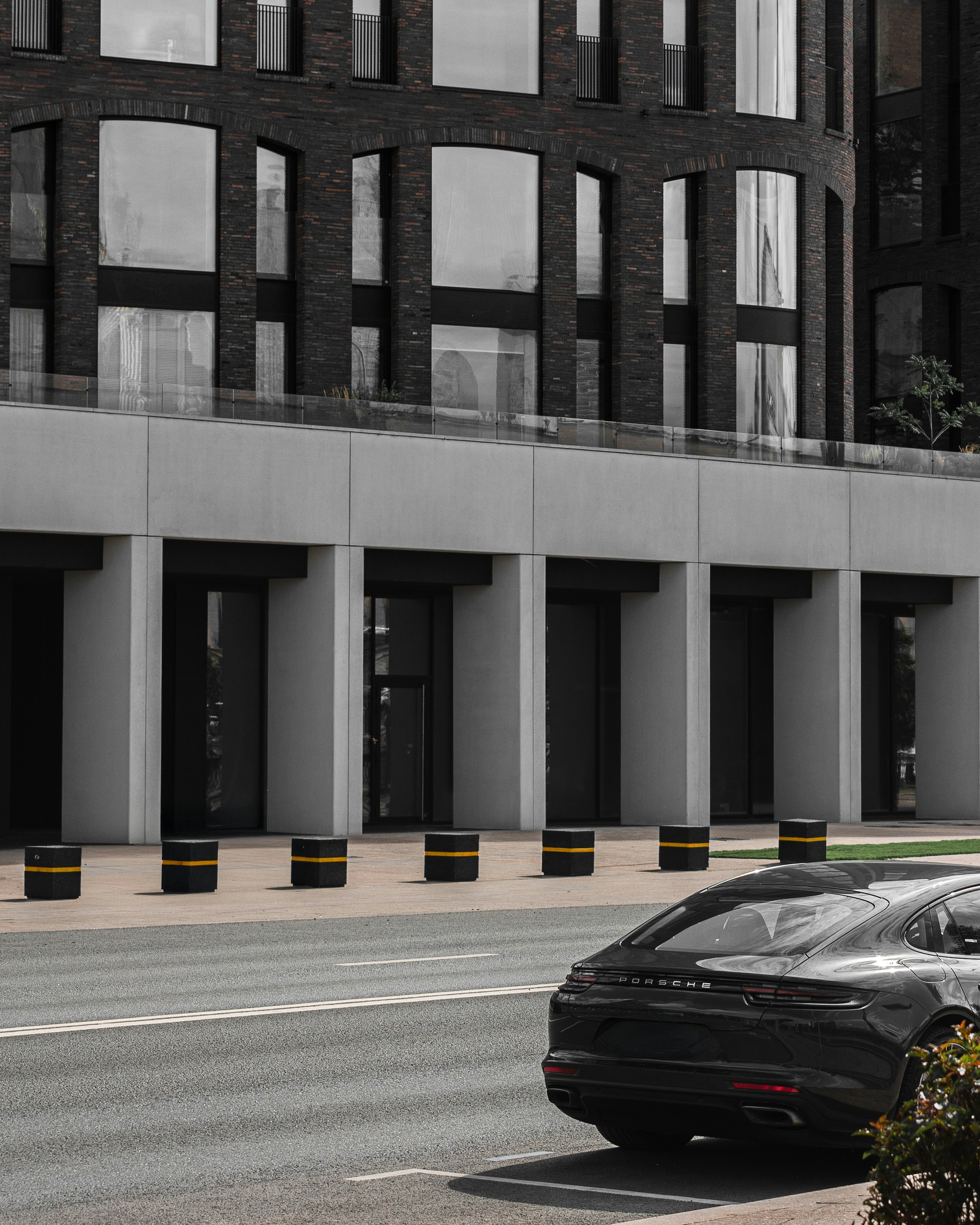Modern building facade with a black car parked nearby.