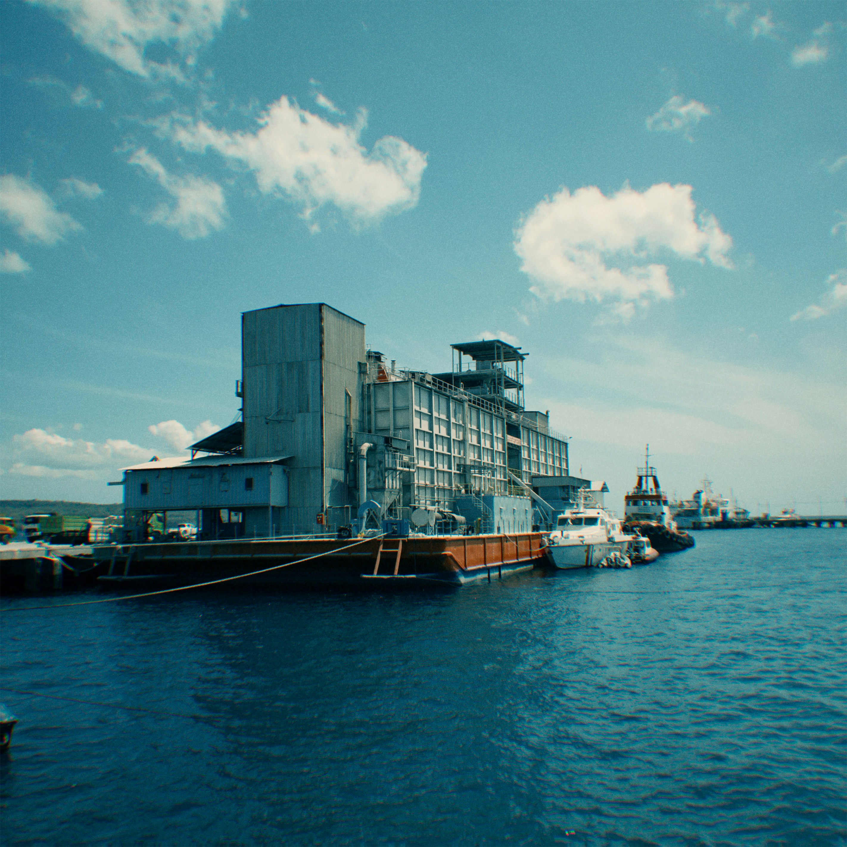 Industrial building on a pier with boats in the harbor.