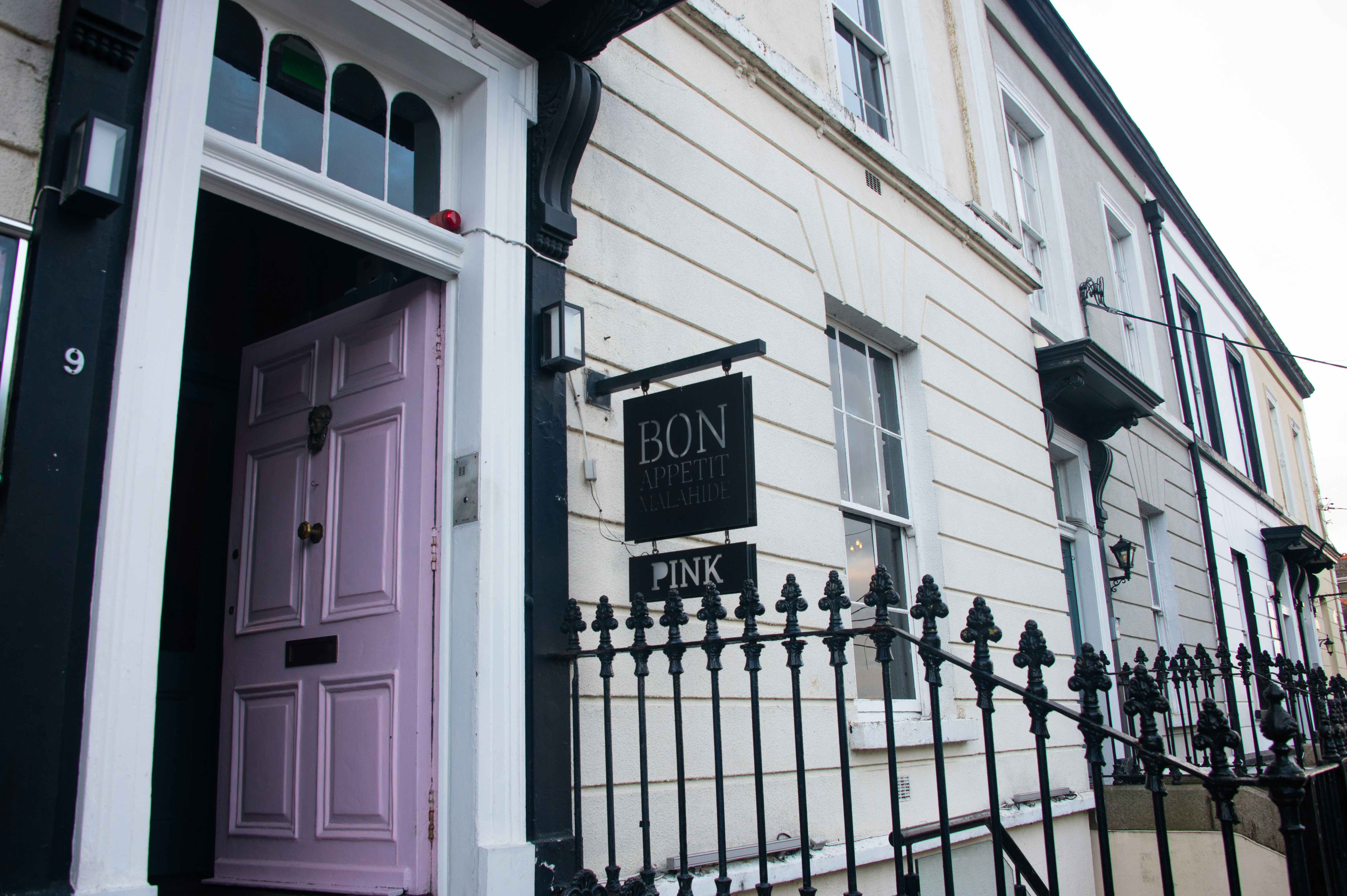 A pastel pink door on a building facade.