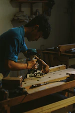 Carpenter using a router on wood at workbench