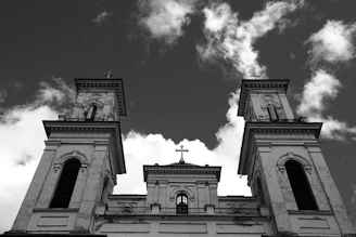 Low angle view of church towers against cloudy sky