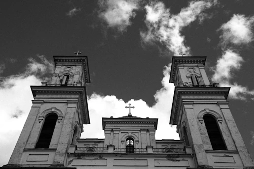 Low angle view of church towers against cloudy sky