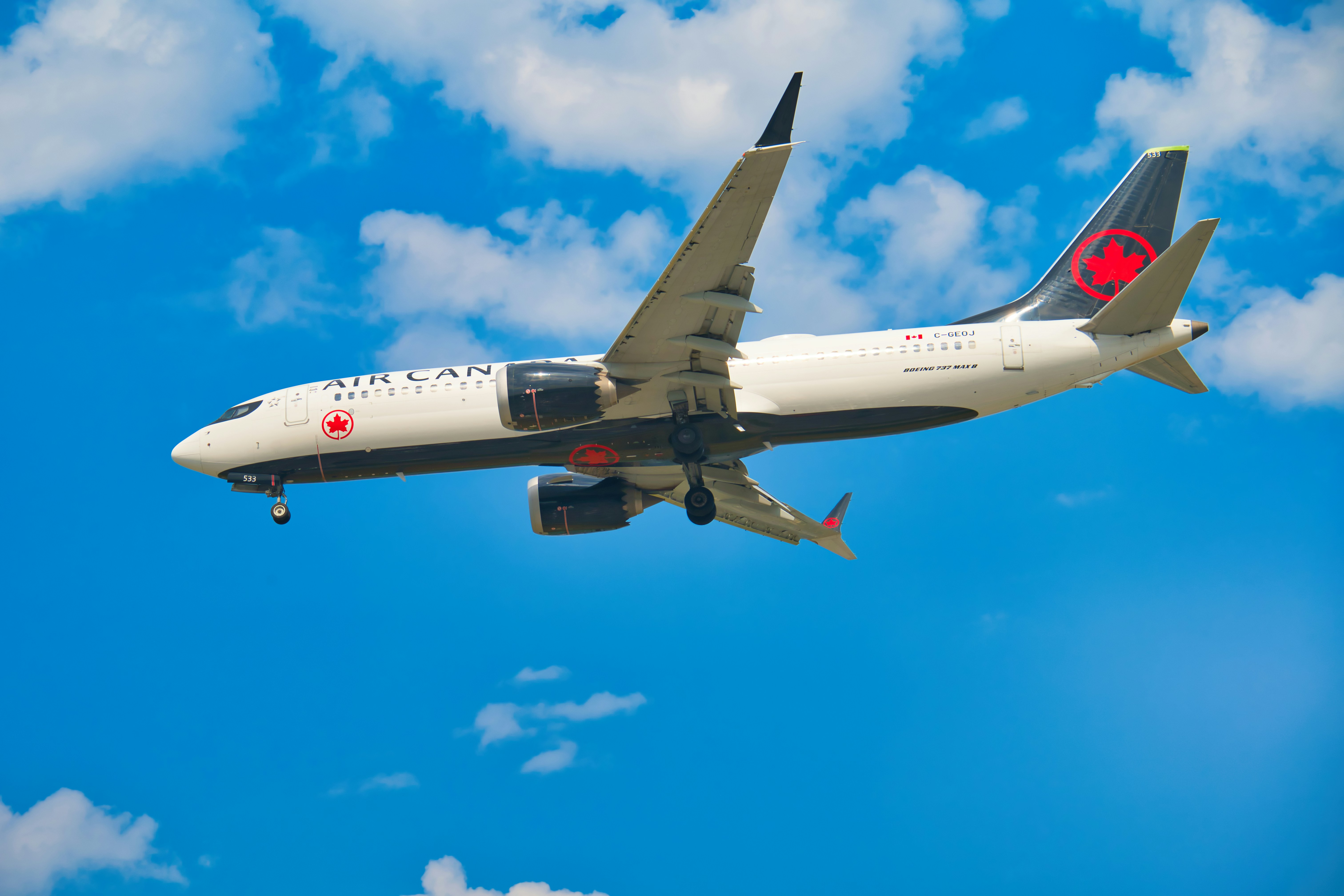 Ein Flugzeug, das durch einen blauen Himmel mit Wolken fliegt